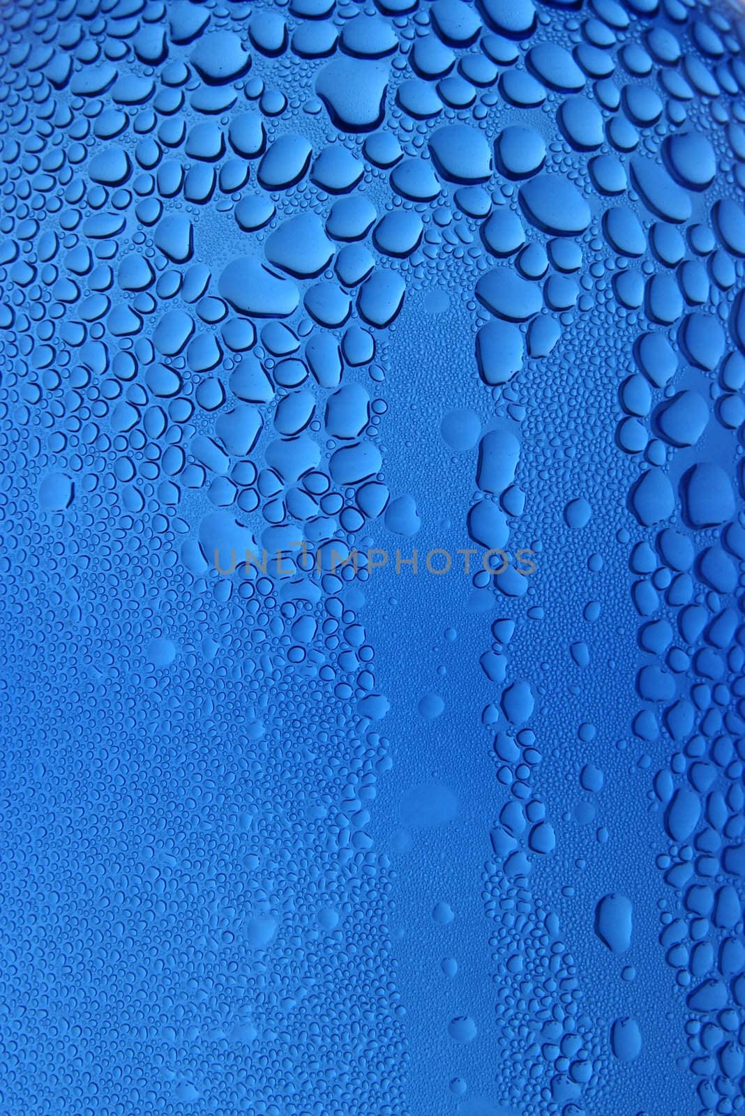 Drops of water clinging to a transparent blue surface