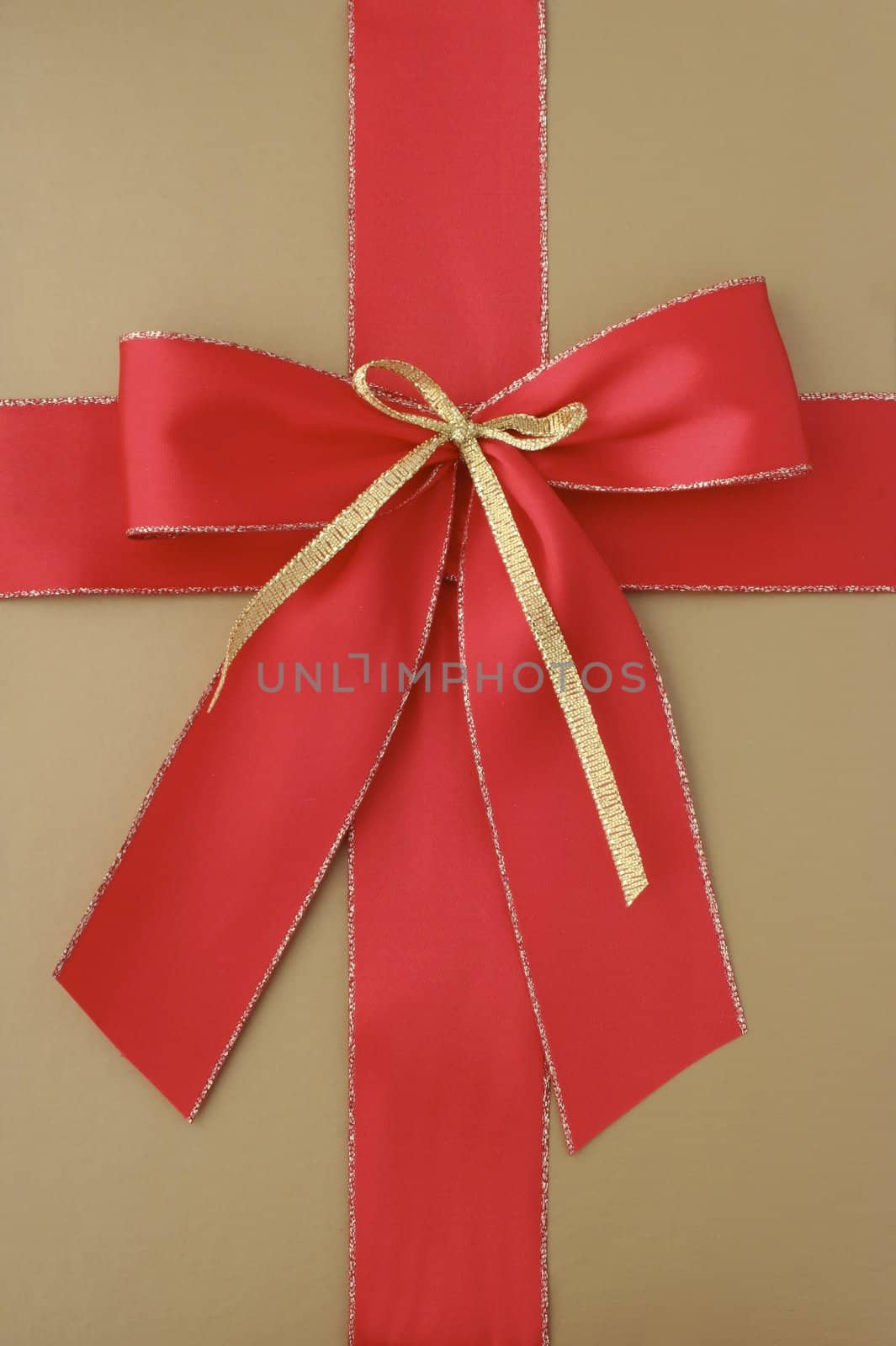 Close-up of a classic giftbox in gold and with a red ribbon