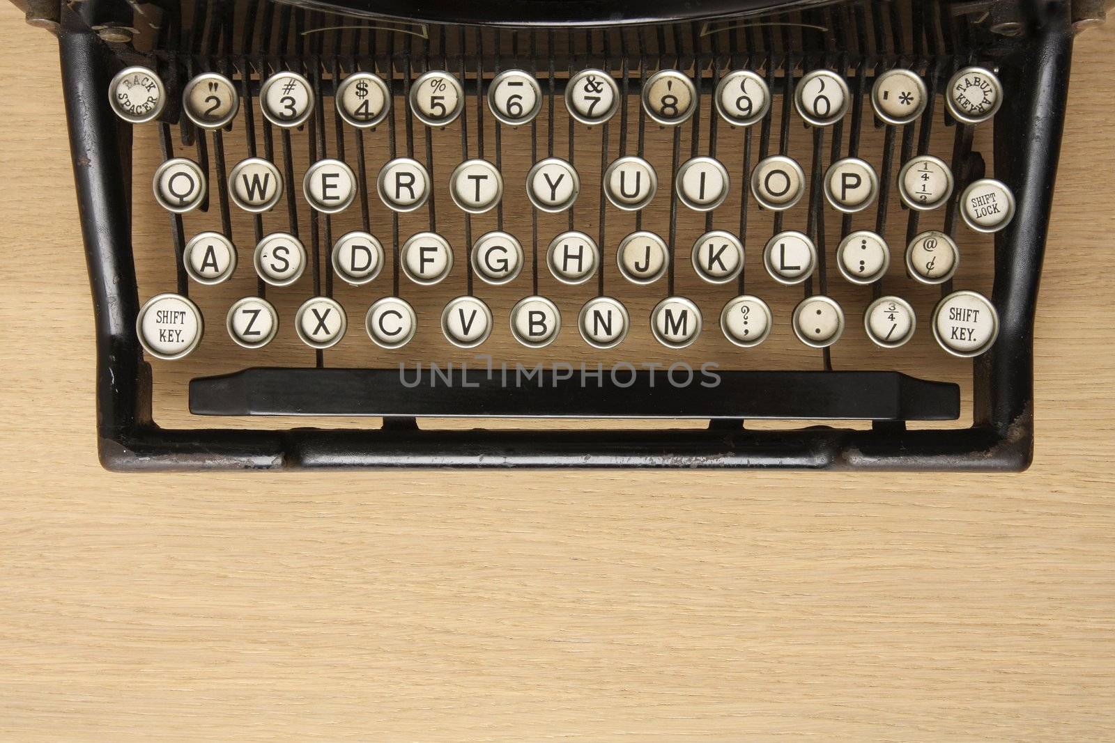 Retro typewriter with qwerty keyboard on a wooden desk