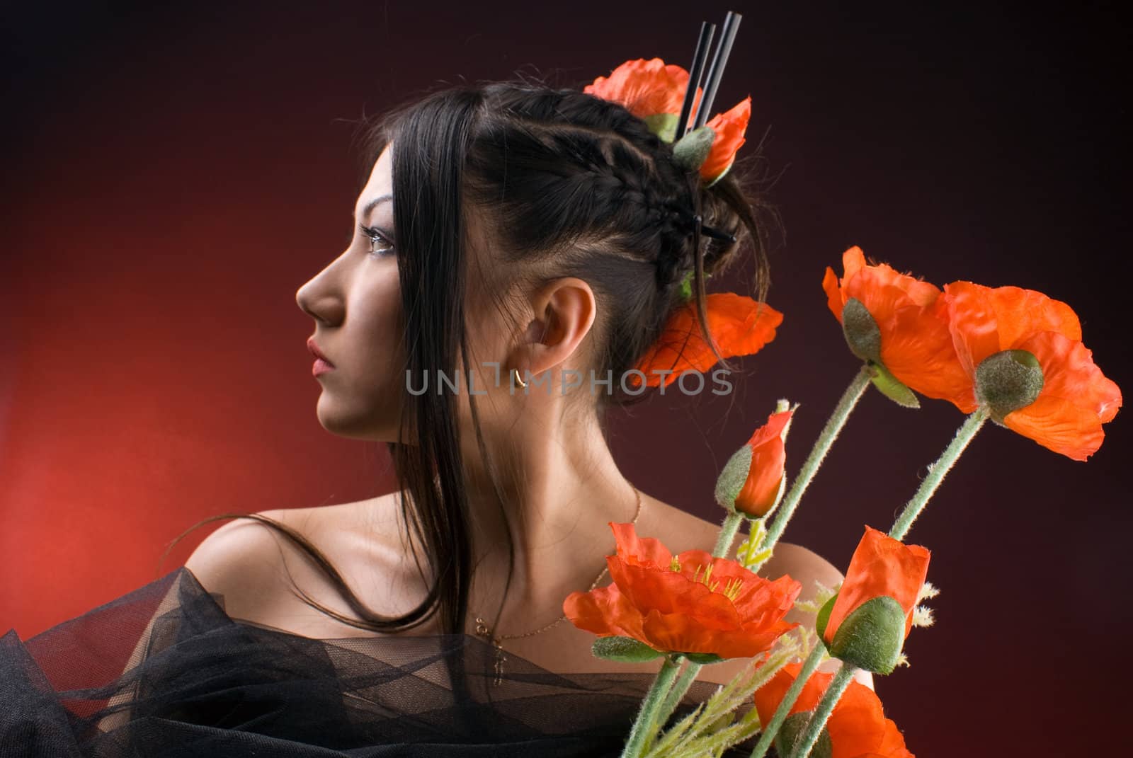 beautiful young asiatic girl with red poppies against red
