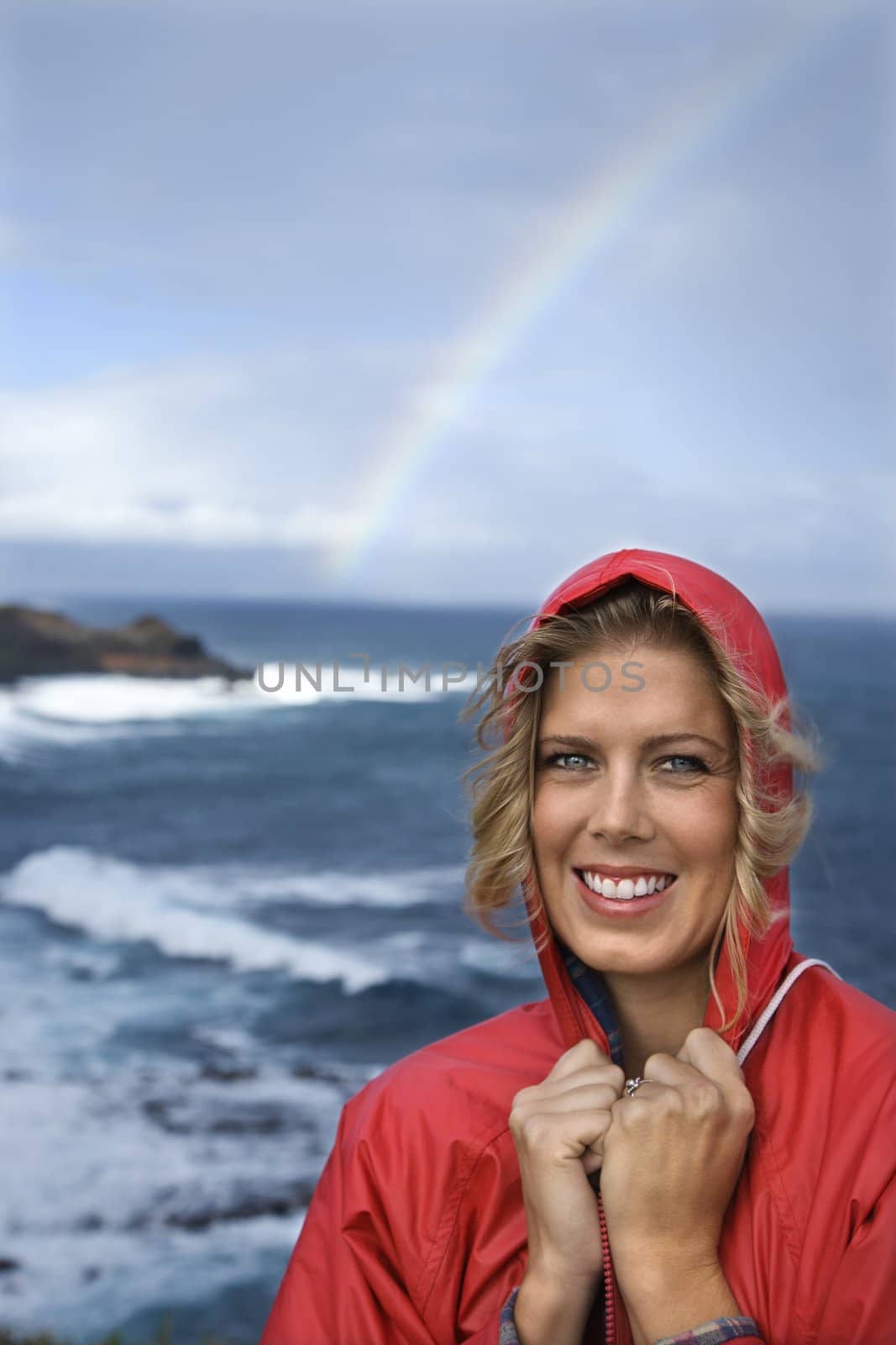 Woman smiling by rainbow. by iofoto