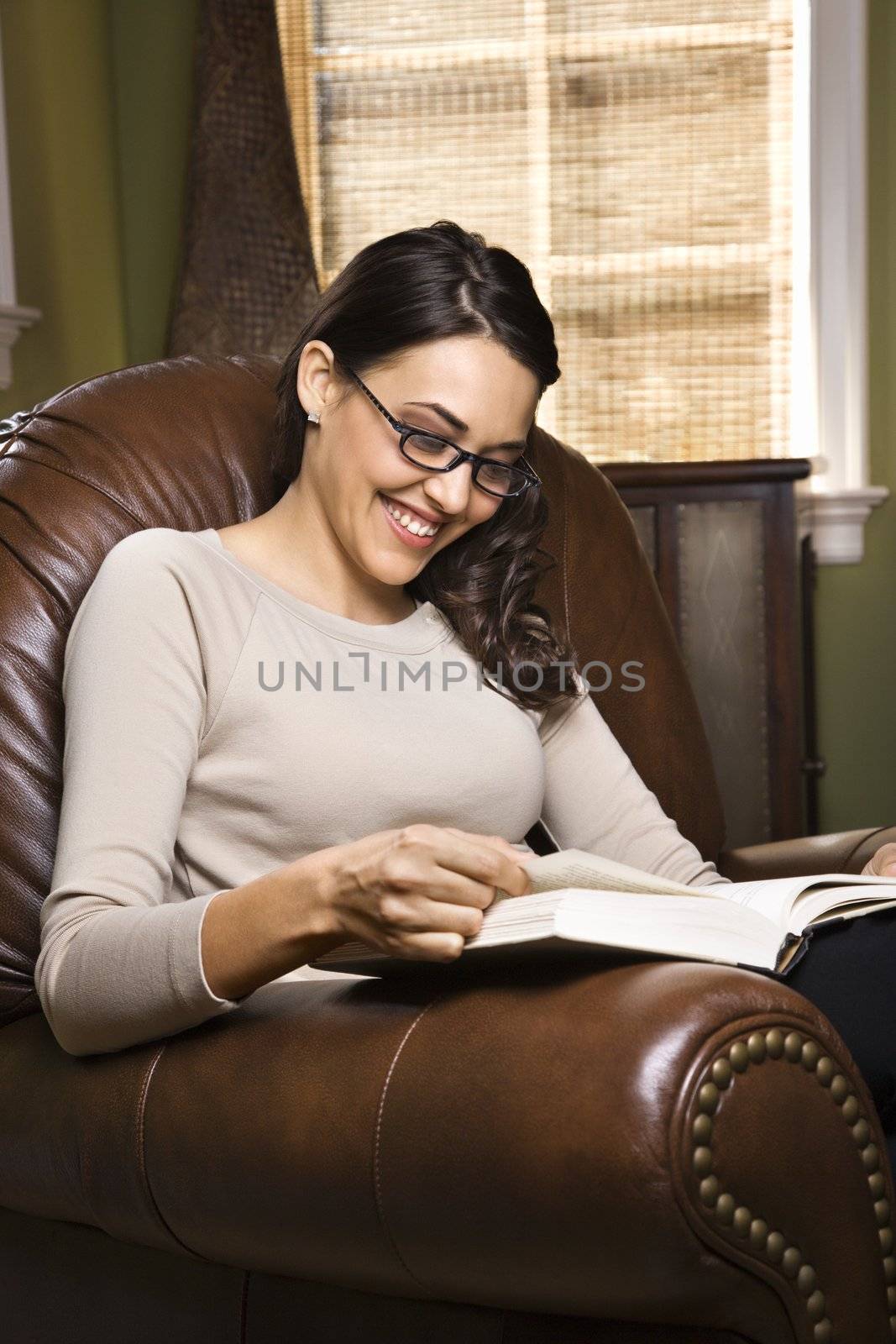 Woman reading and smiling. by iofoto