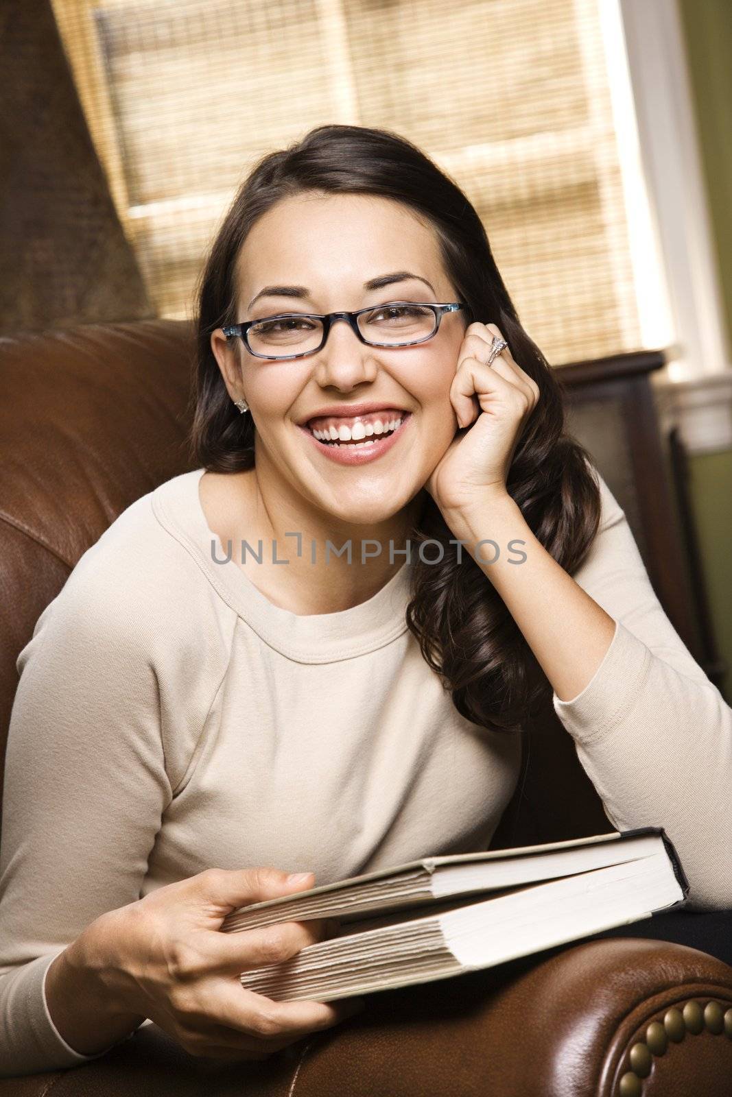 Woman smiling with book. by iofoto