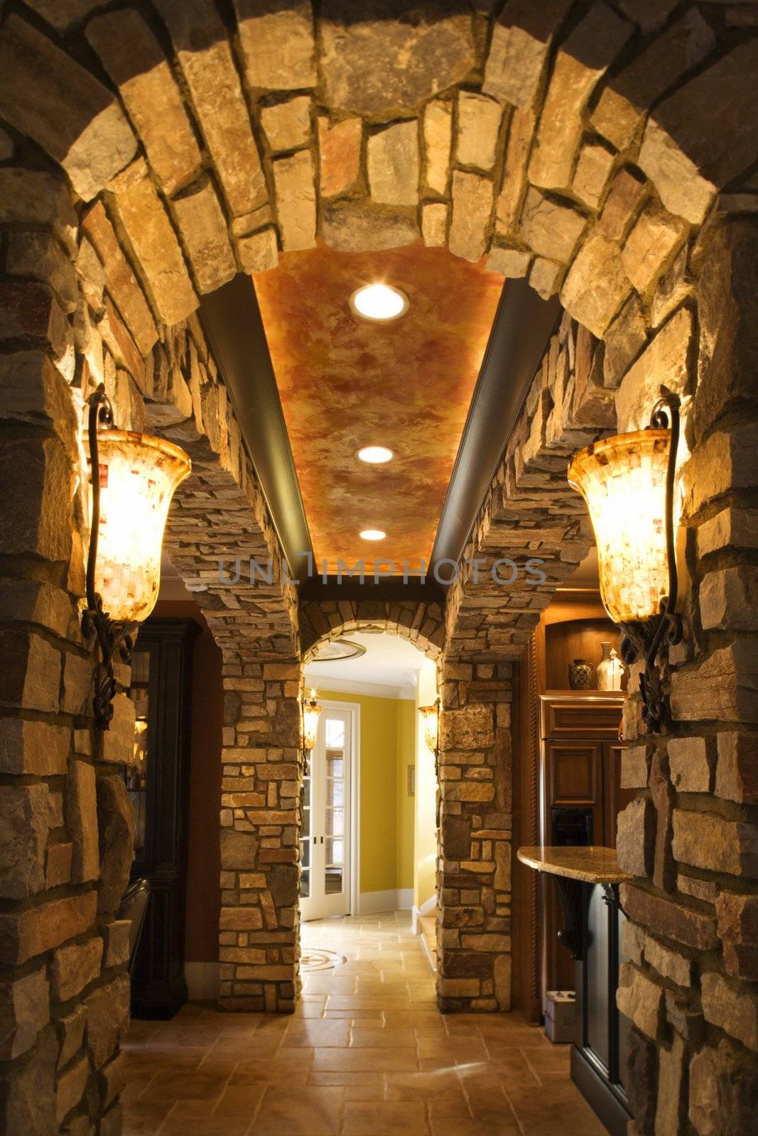 View of foyer through stone archway in affluent home.