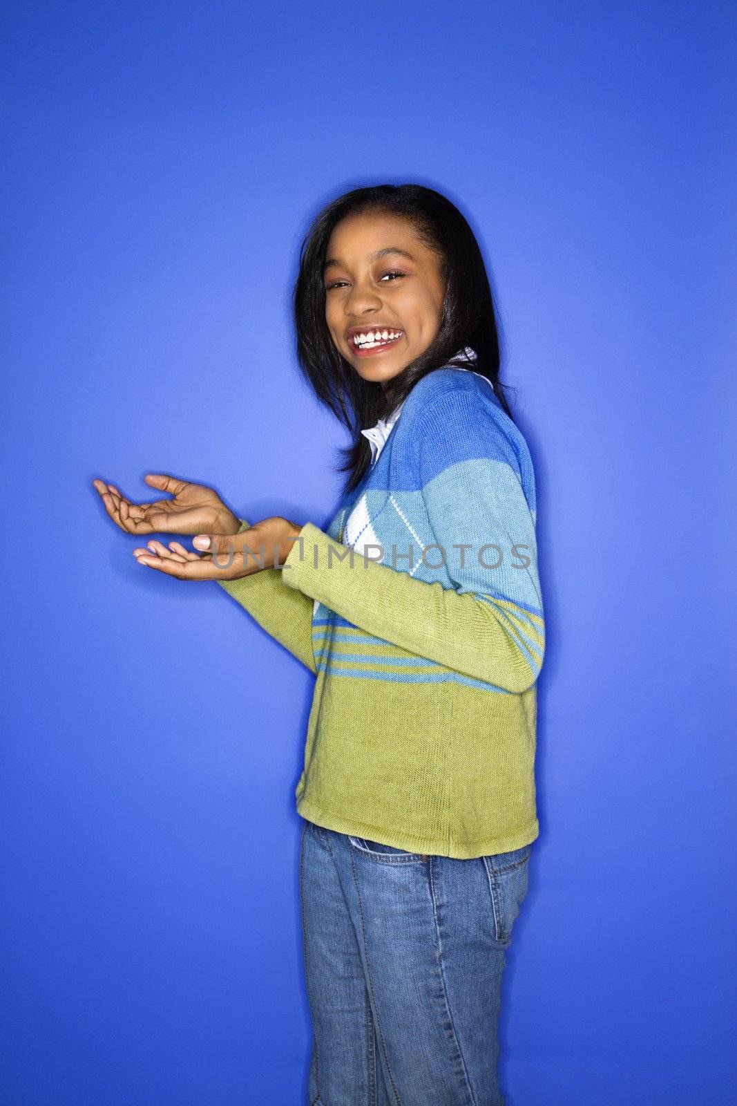 Portrait of African-American teen girl with palms turned upward.