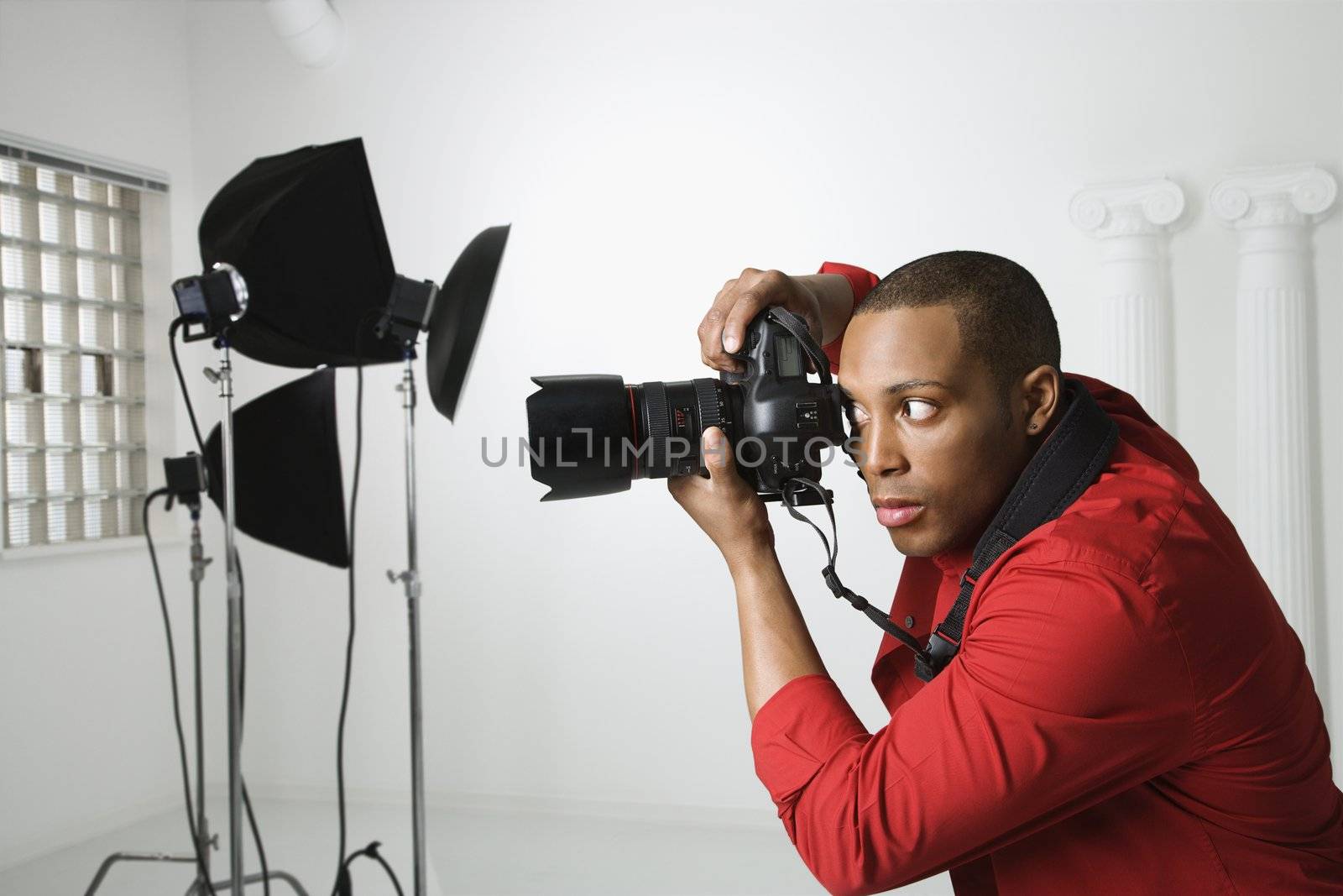 African American young male adult photographing in studio.