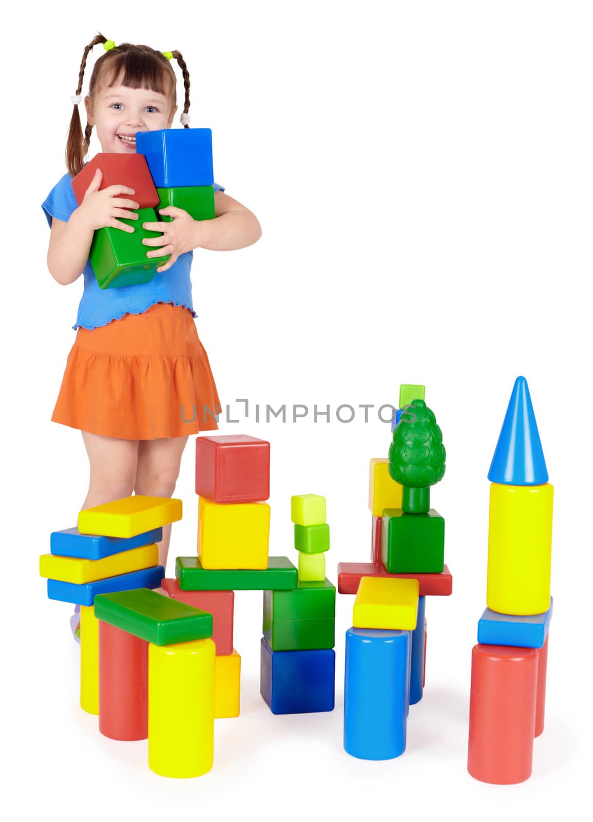 Happy child builds a castle out of color blocks