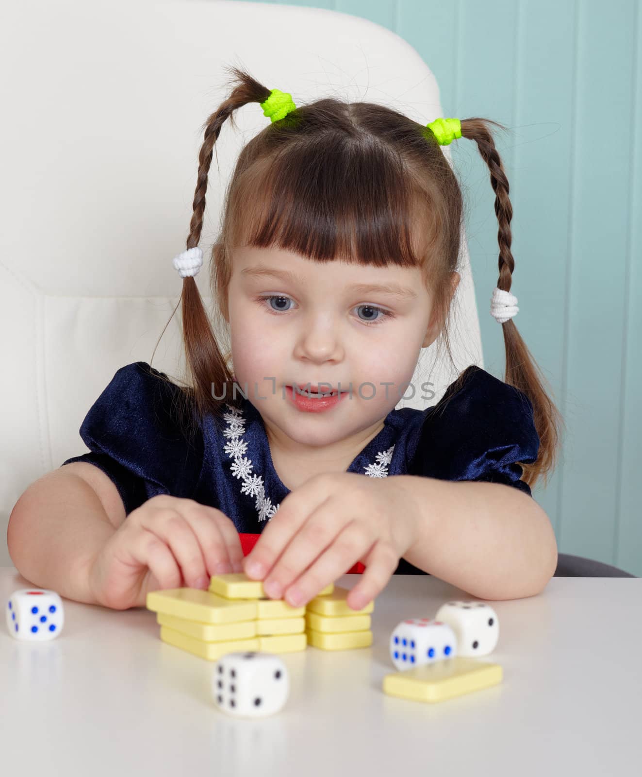 The happy beautiful child plays with toys on the table