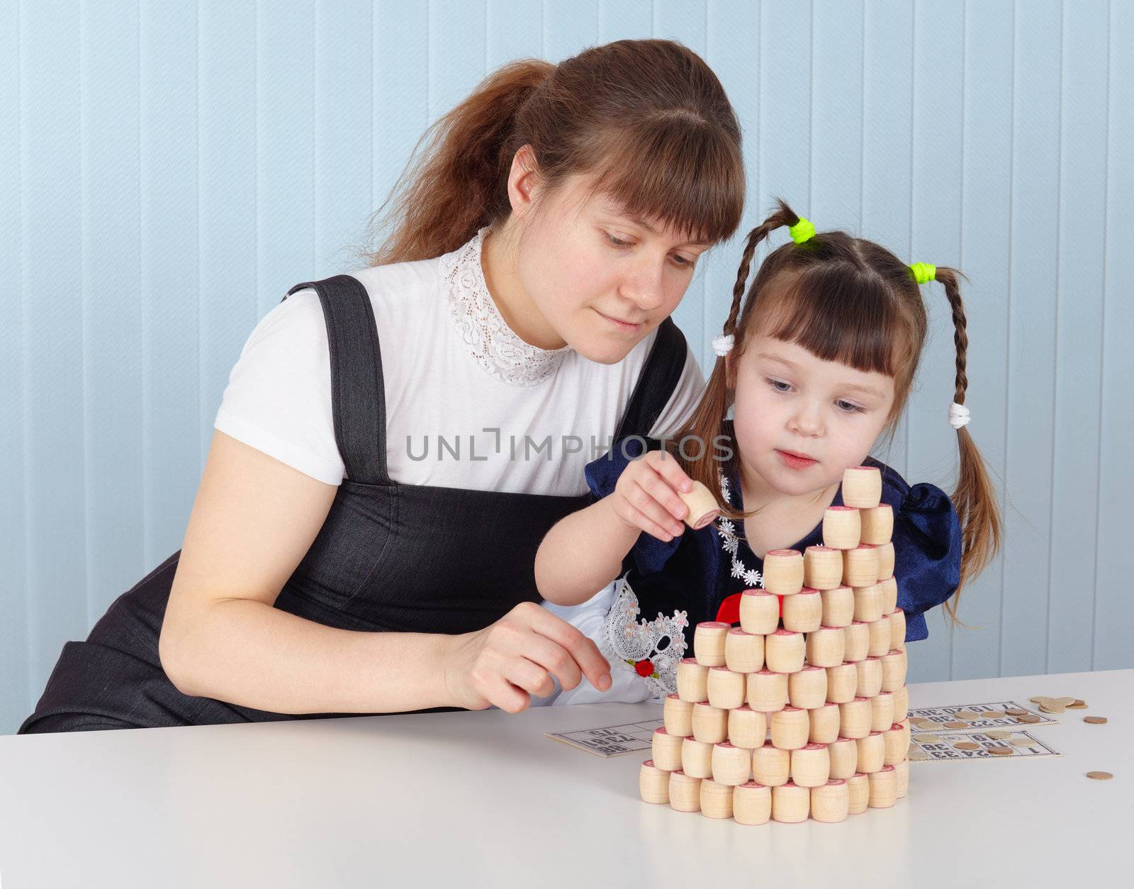 Mother and daughter are building a tower of bingo