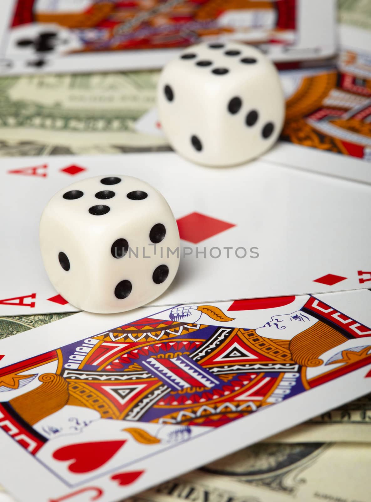 Dice against the background of playing cards and money