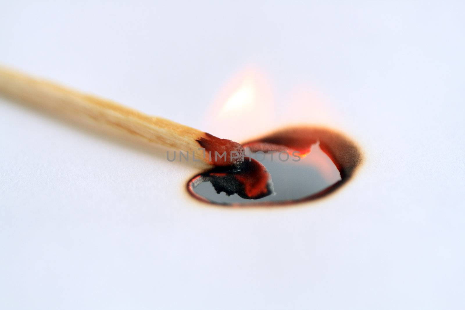 Burned match with fire flame lying on paper with copy space