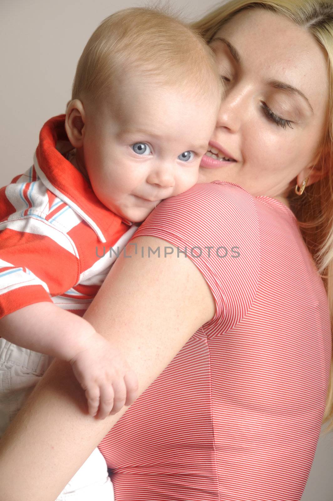 Young happy mother with boy baby in red t-shorts