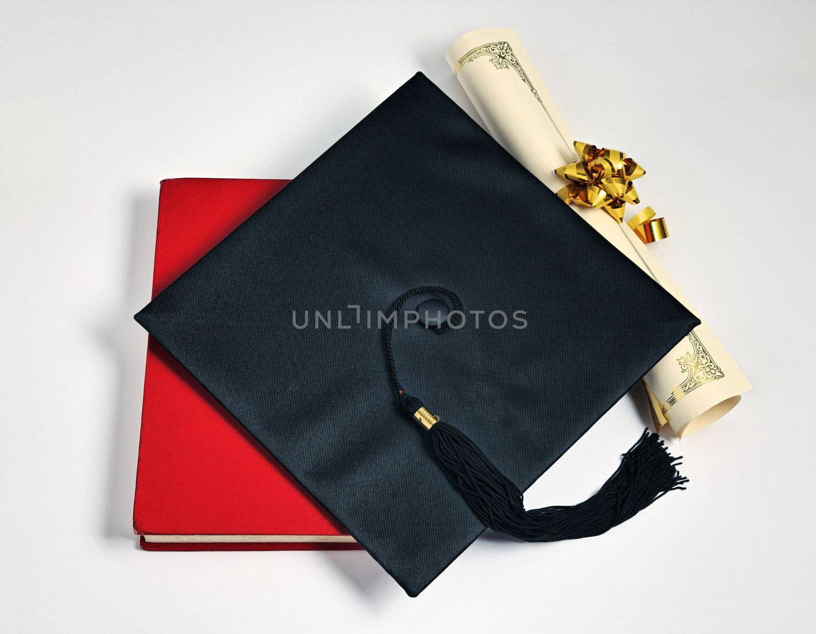Graduation cap and diploma on the plain background

