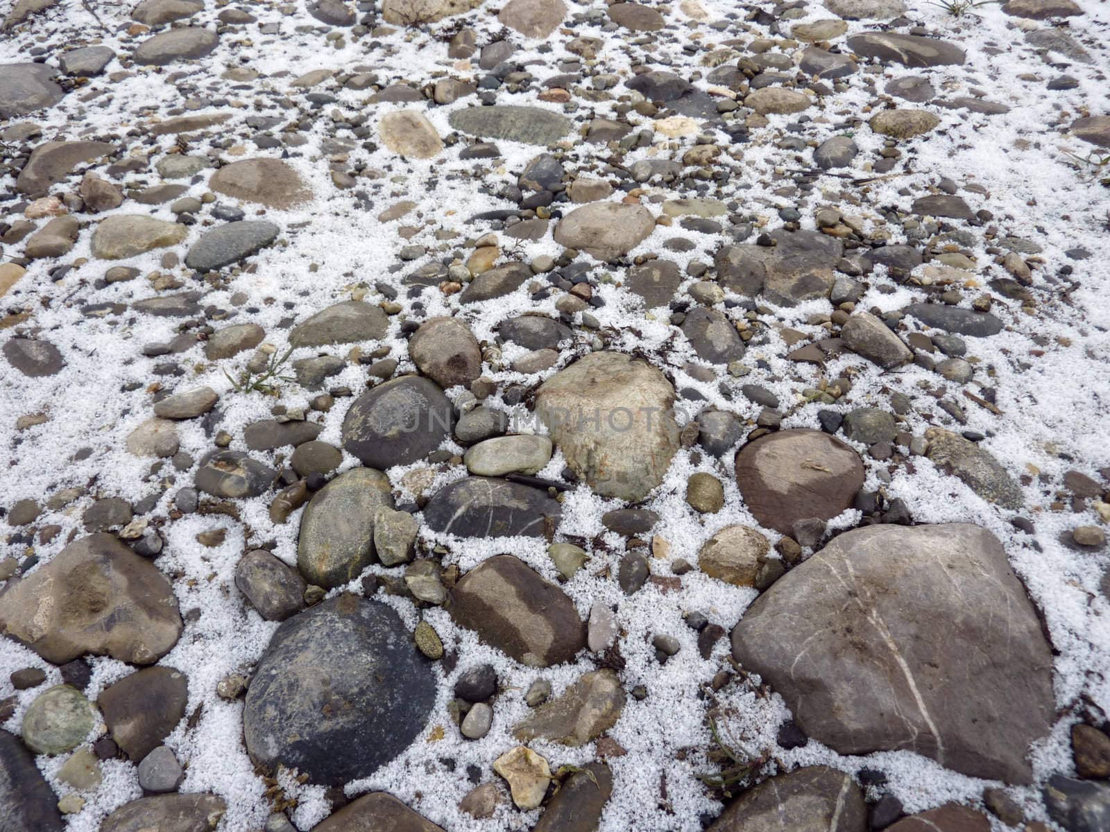 Close up of grey stones and pebbles with snow