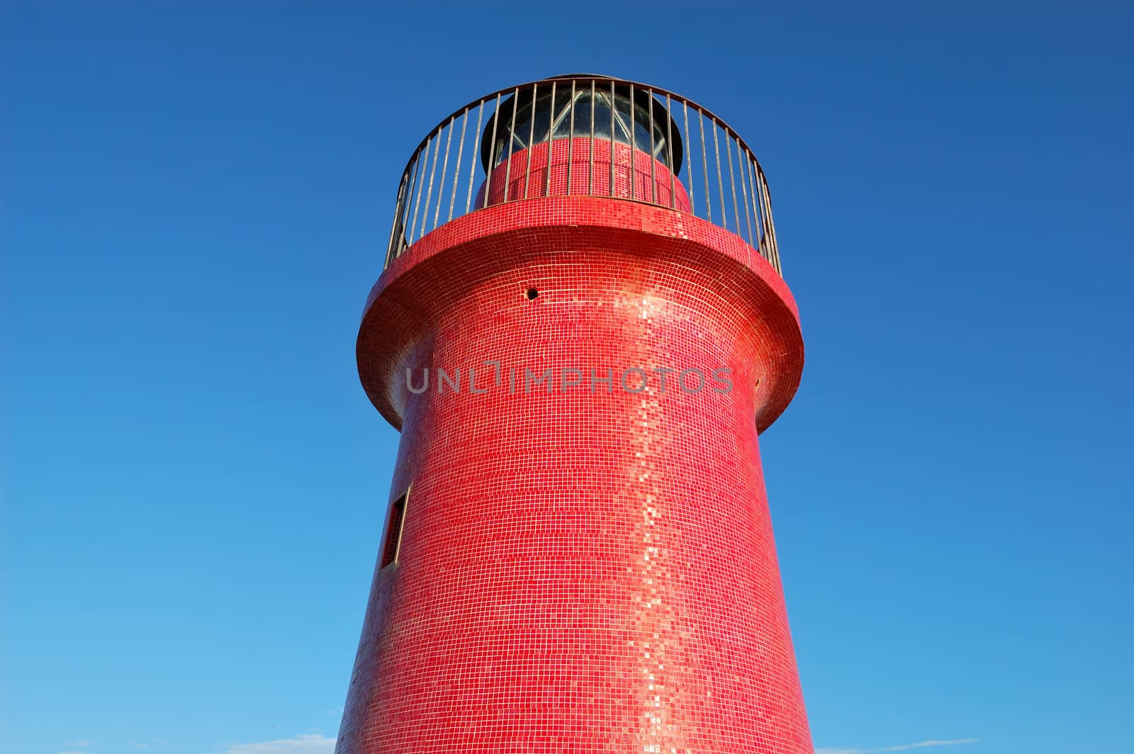 red lighthouse against a summer deep blue sky