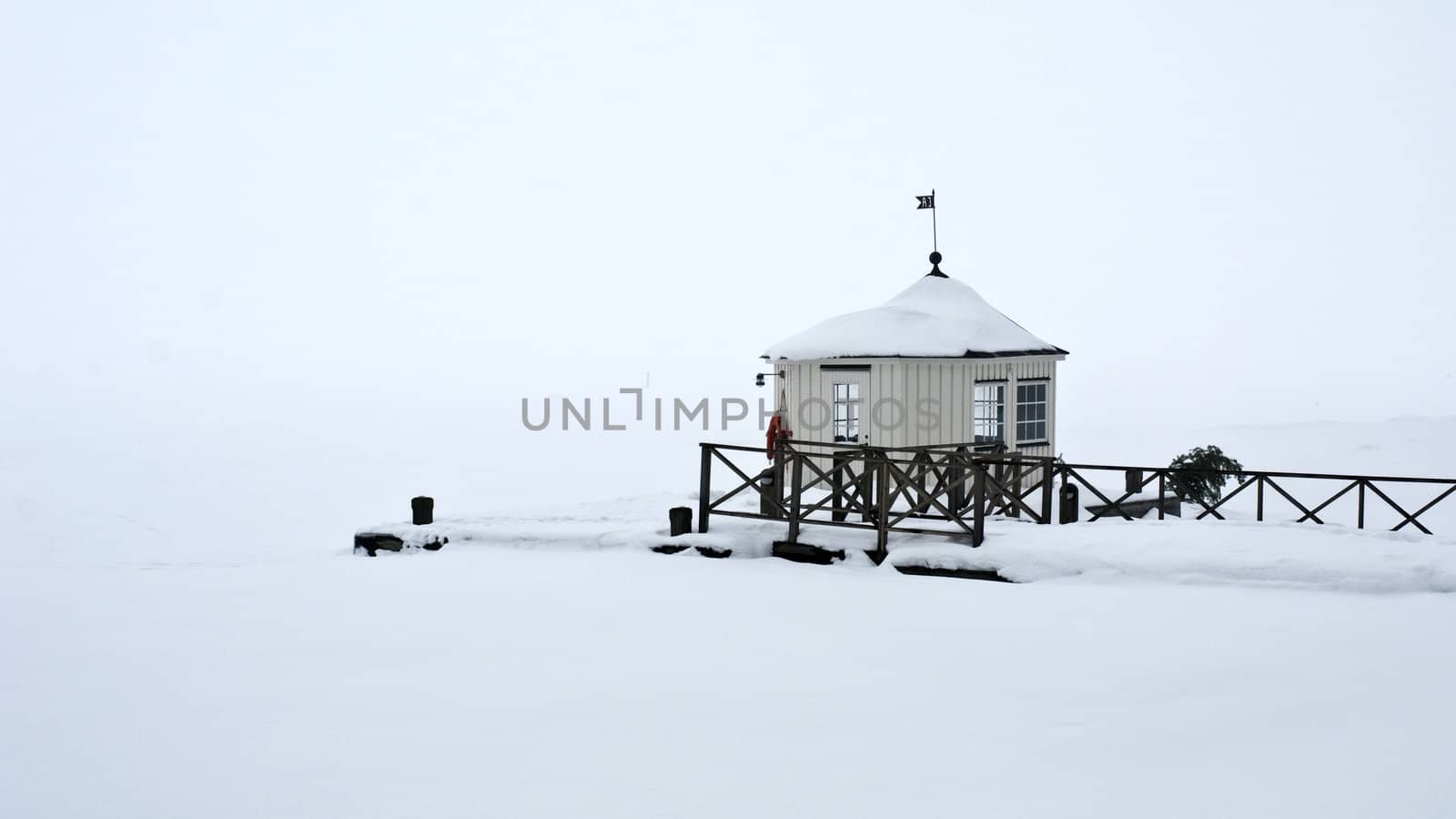 A pier with a house on a foggy winters day