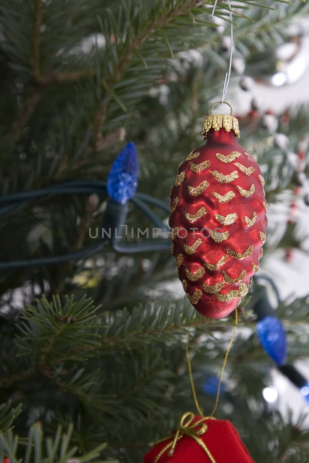 red christmas bulb in the shape of a pine cone hanging from the tree