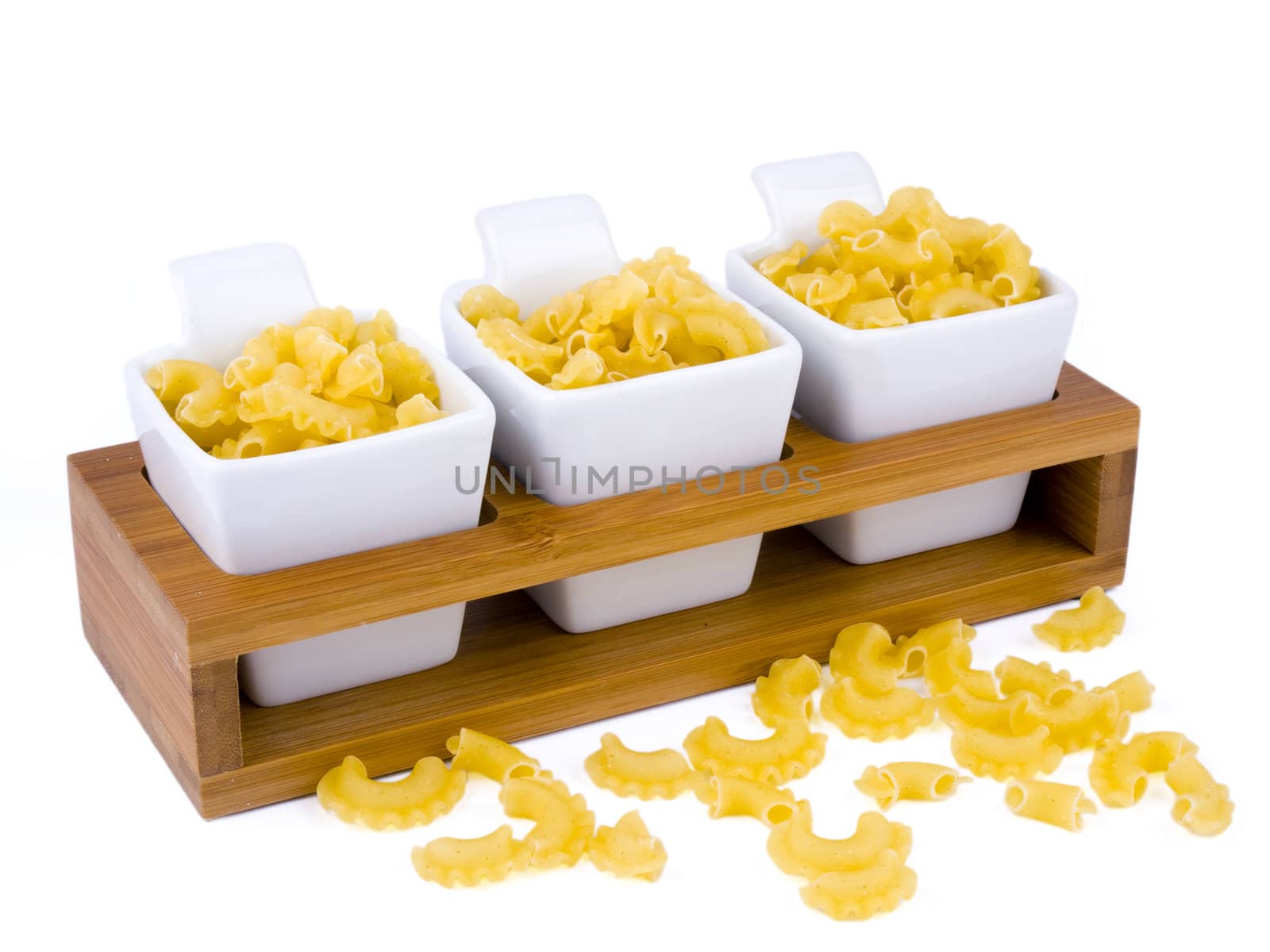 Three porceline bowls filled with pasta on white background