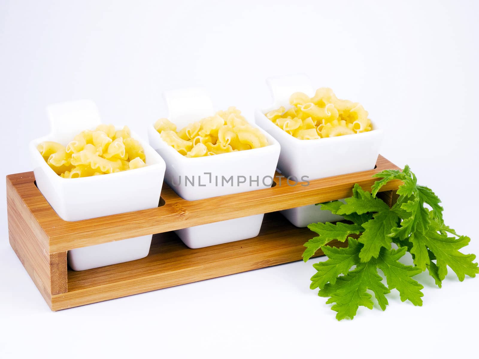 Three porceline bowls filled with pasta on white background