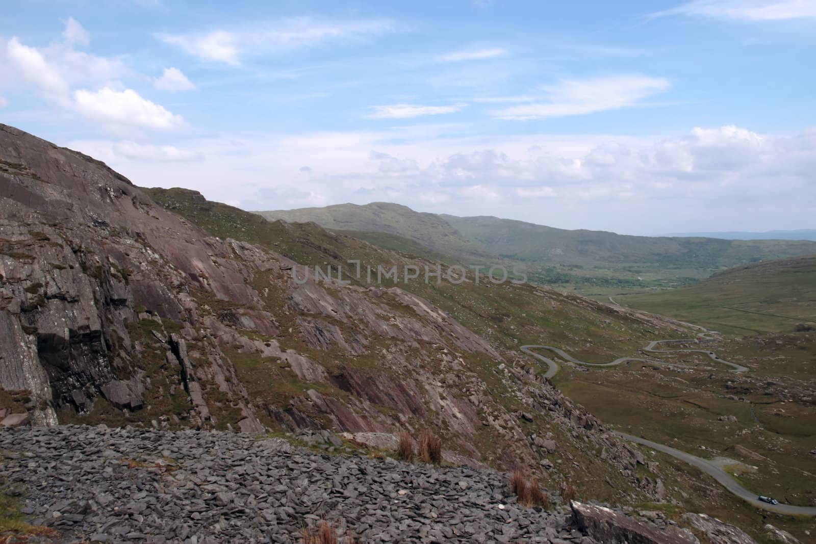 an evening view of winding roads through the mountains of kerry with vintage cars on the roads