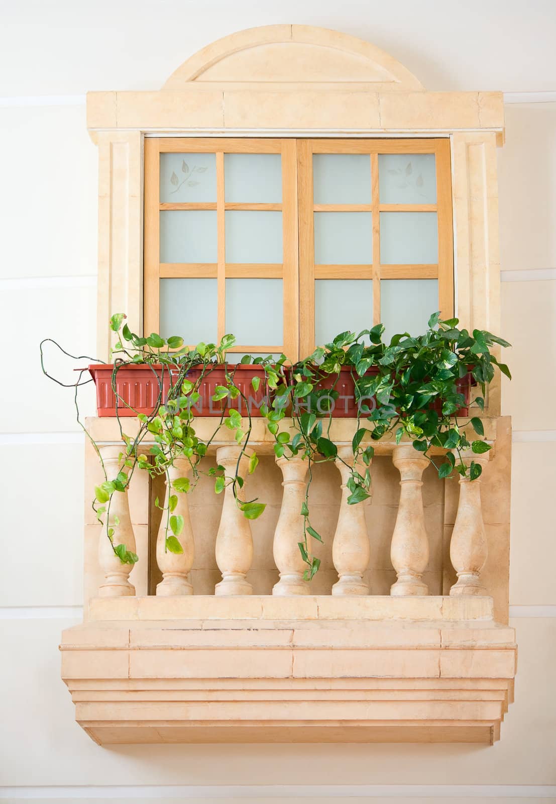 Unusual decorative balcony with columns and vases with flowers.