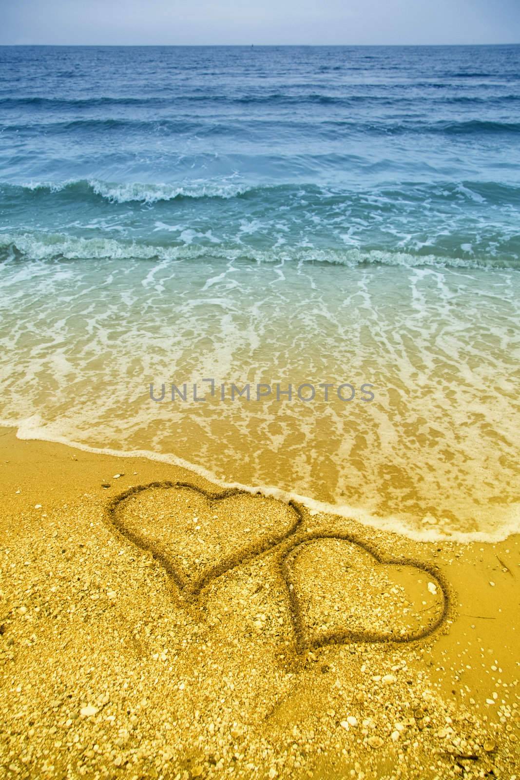 Drawing of two hearts in the sand on beach