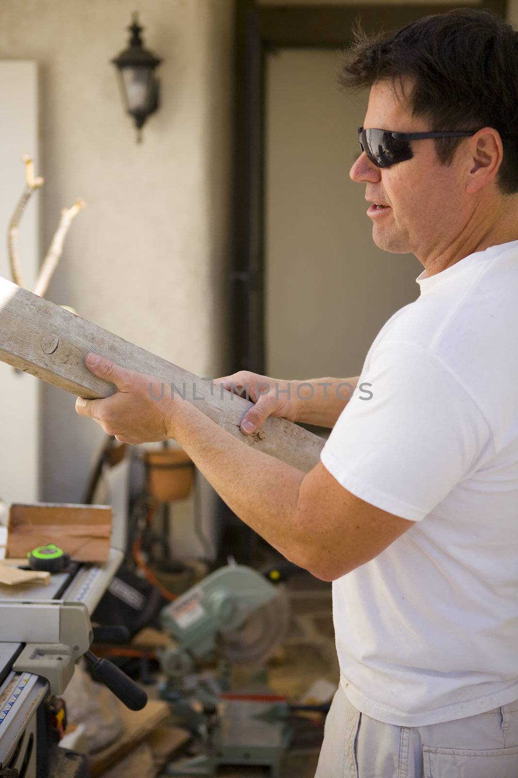 Man working around the house with Wood