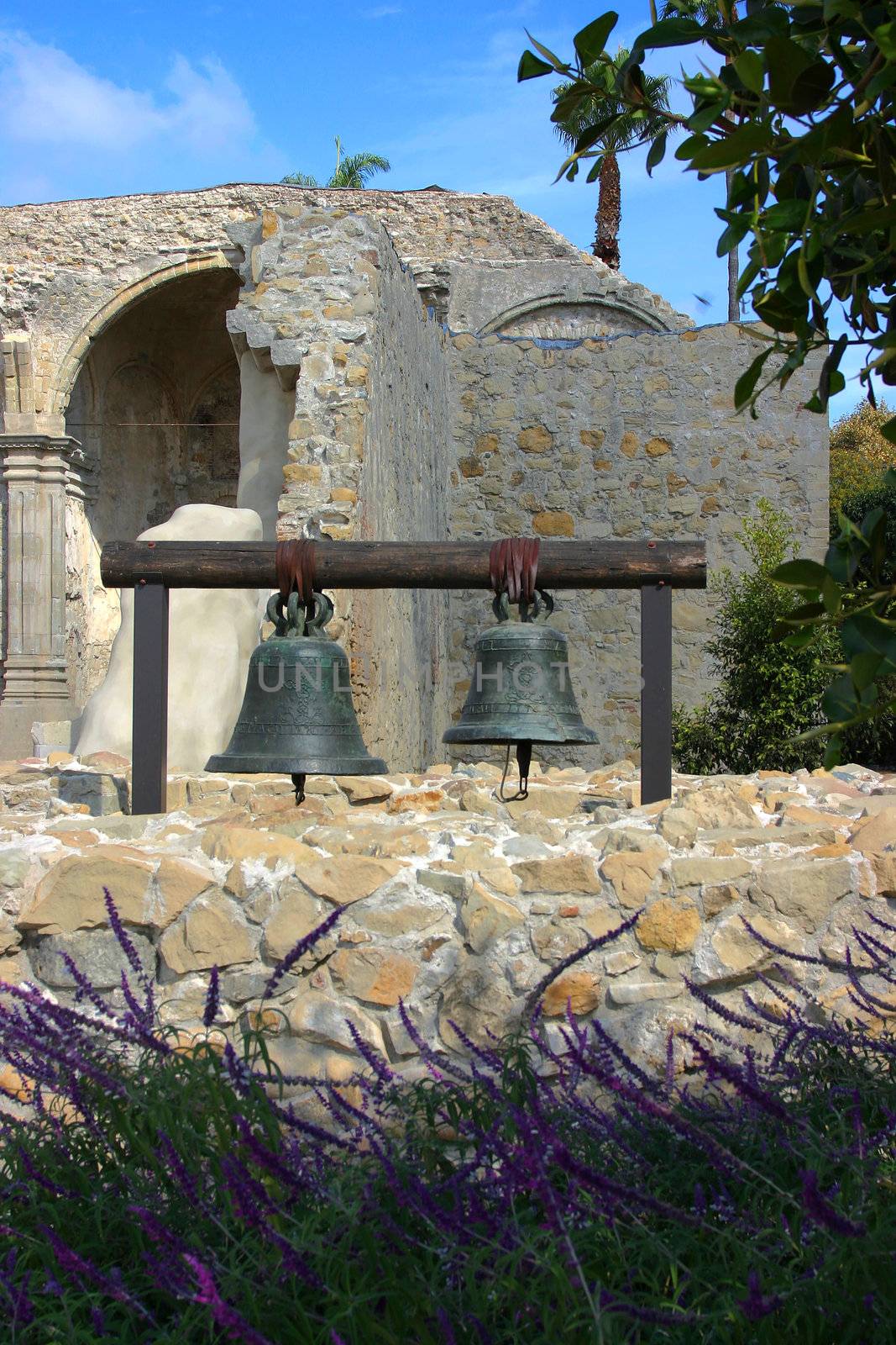 Two Bells hanging at Mission San Juan Capistrano with the ruins in the background.