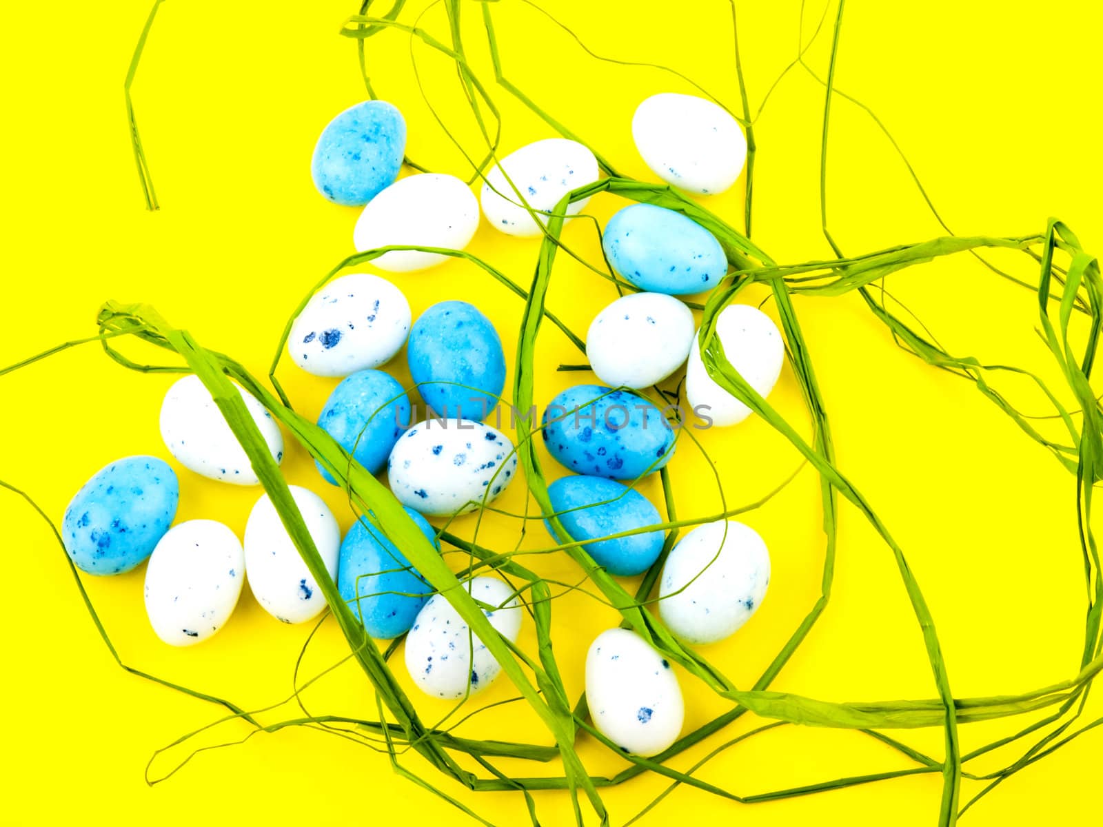 White and blue easter eggs on yellow background.