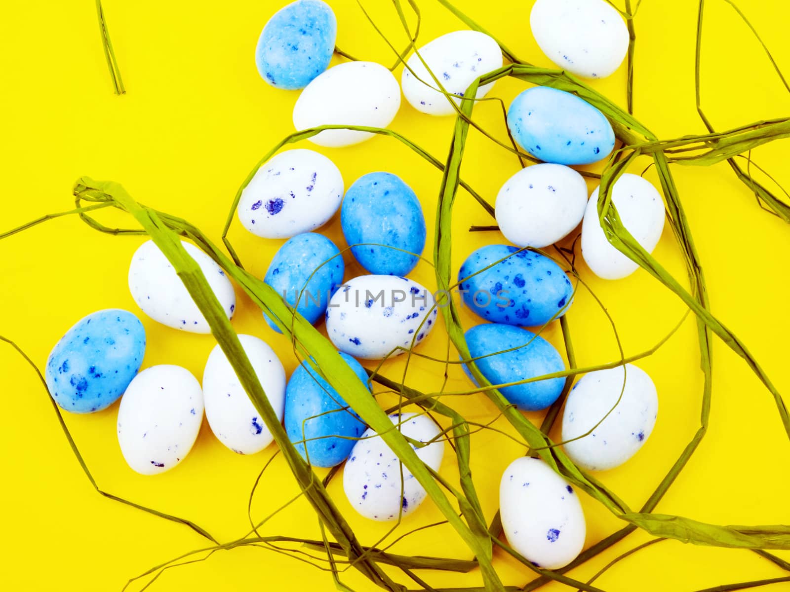 White and blue easter eggs on yellow background.