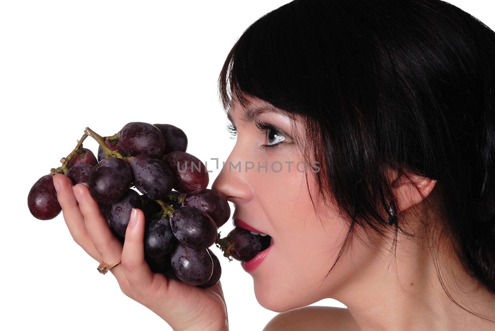 a young charming brunette eating grapes