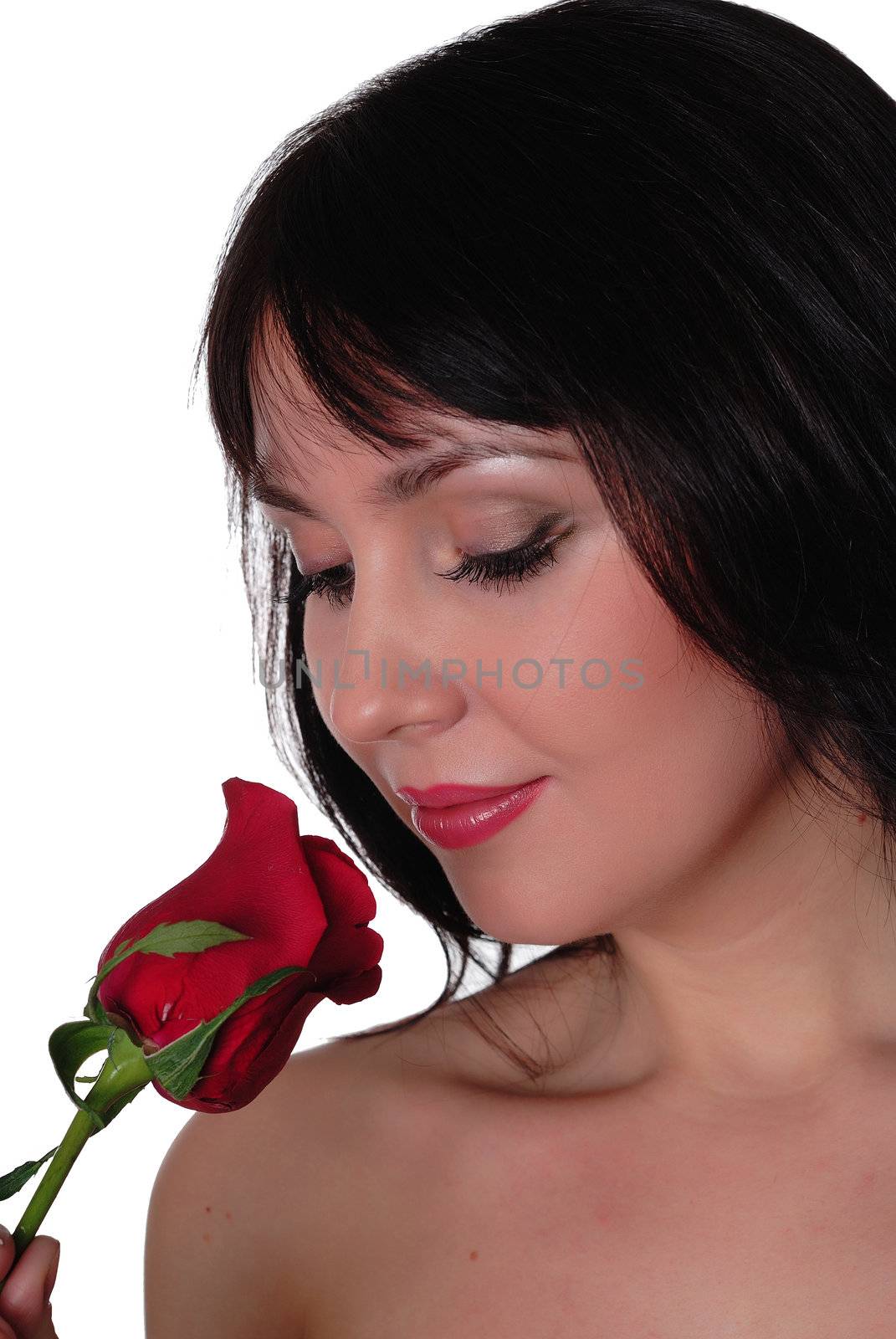 a charming brunette looking at a red rose