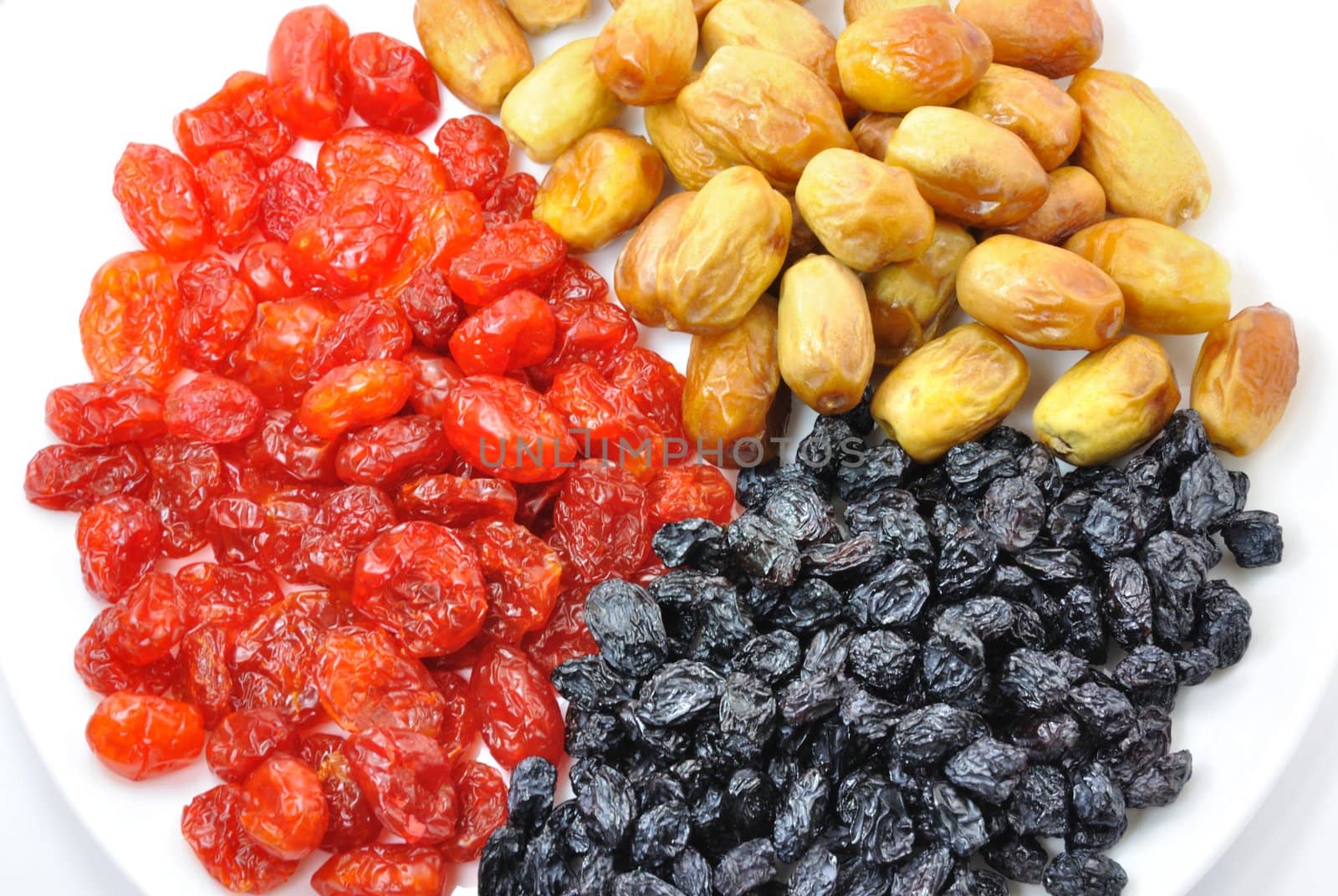 Dried Dates, Cornelian Cherries and Black Raisins on White Plate Isolated, Close-Up