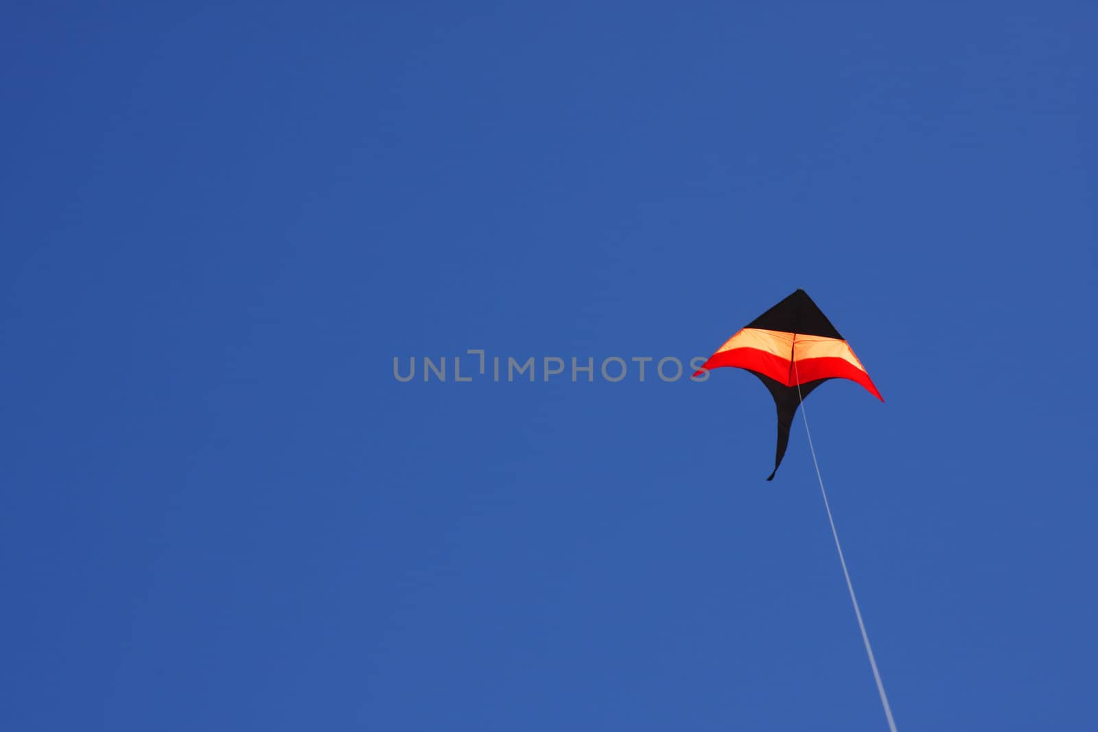 Colorful kite flying in a clear blue sky