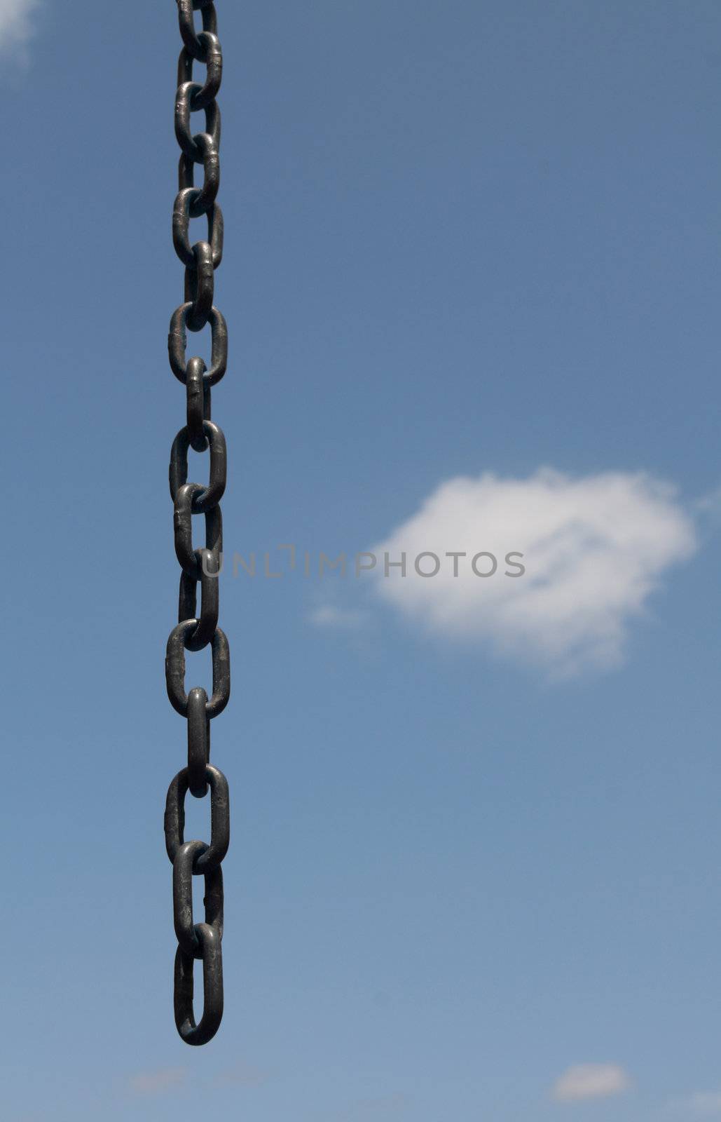 an opened broken chain over a blue clouded sky