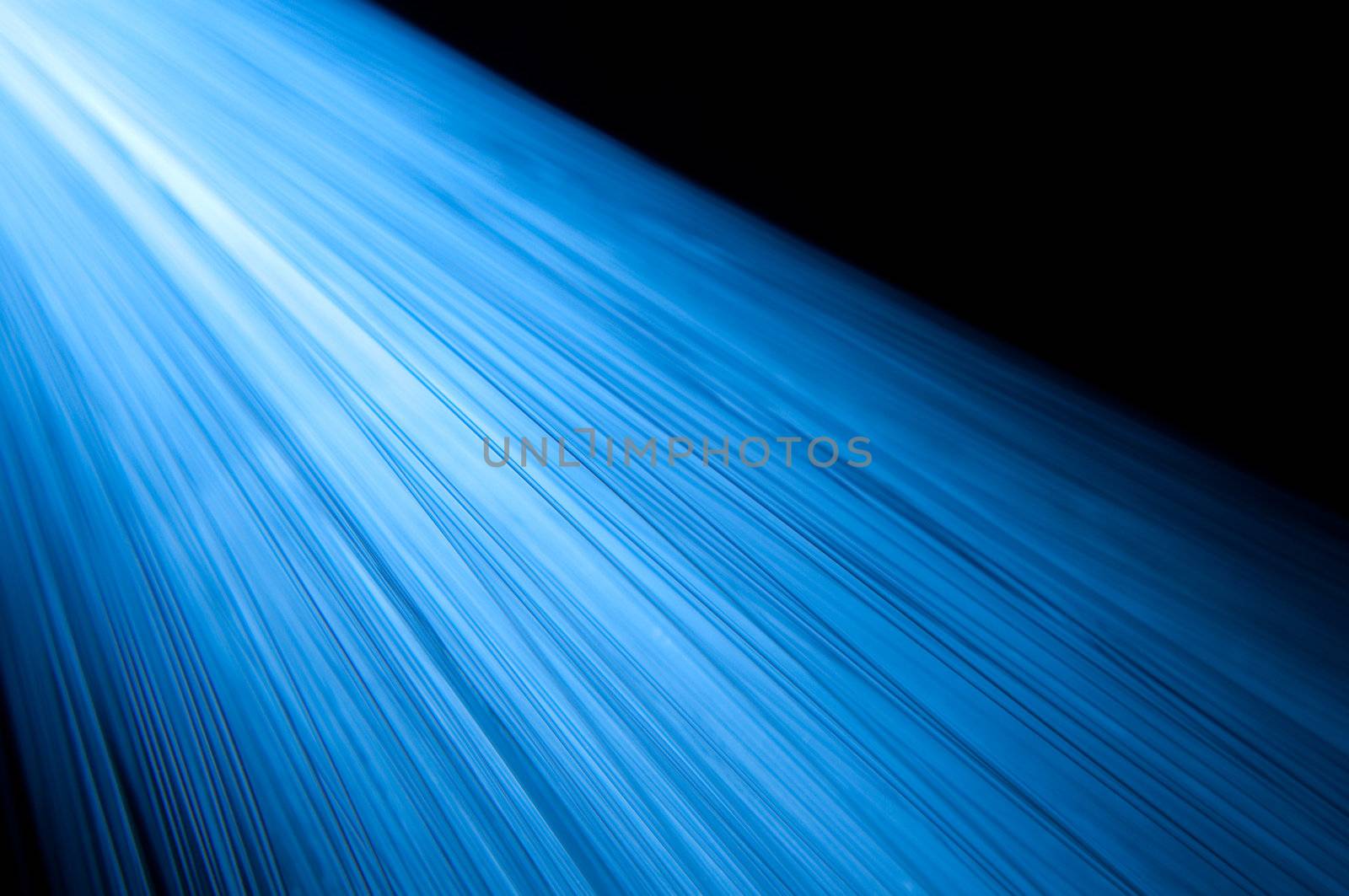 Close up capturing many vibrant blue fibre optic light strands arranged over black.