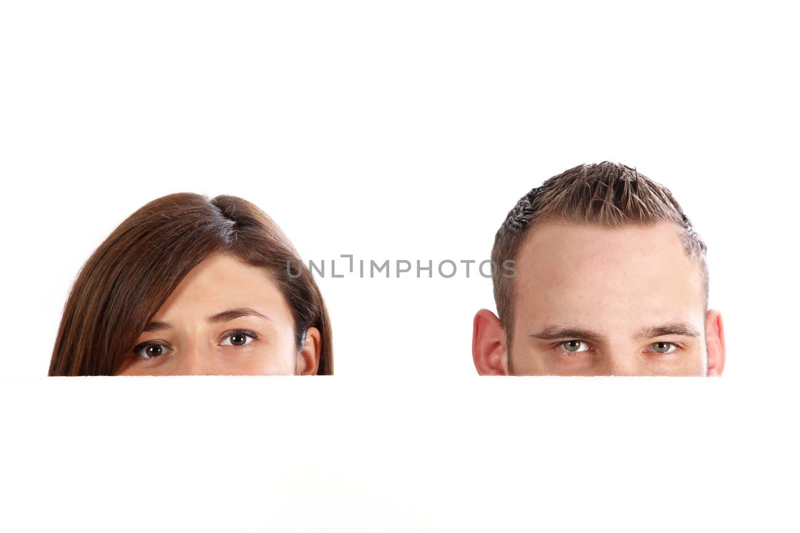Young couple behind a wall, only the eyes are visible. With space for text