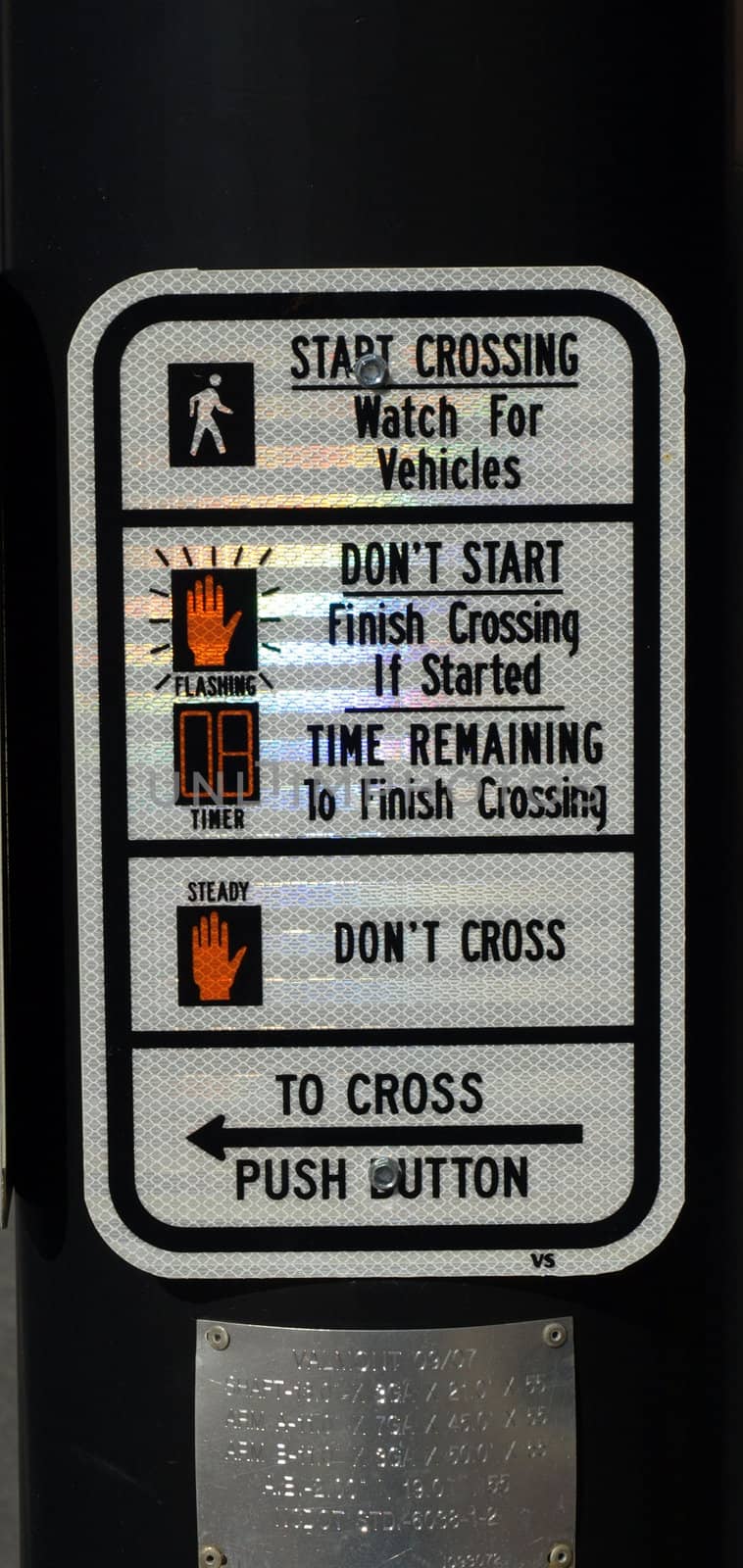 A street crossing sign at a busy intersection