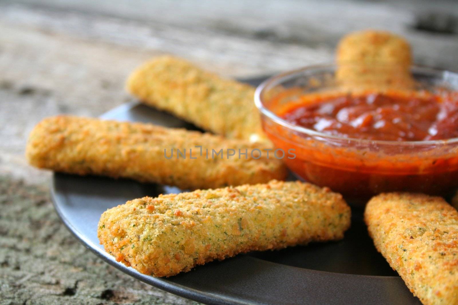 Appetizer of mozzarella cheese sticks with marinara sauce. Used a shallow depth of field.