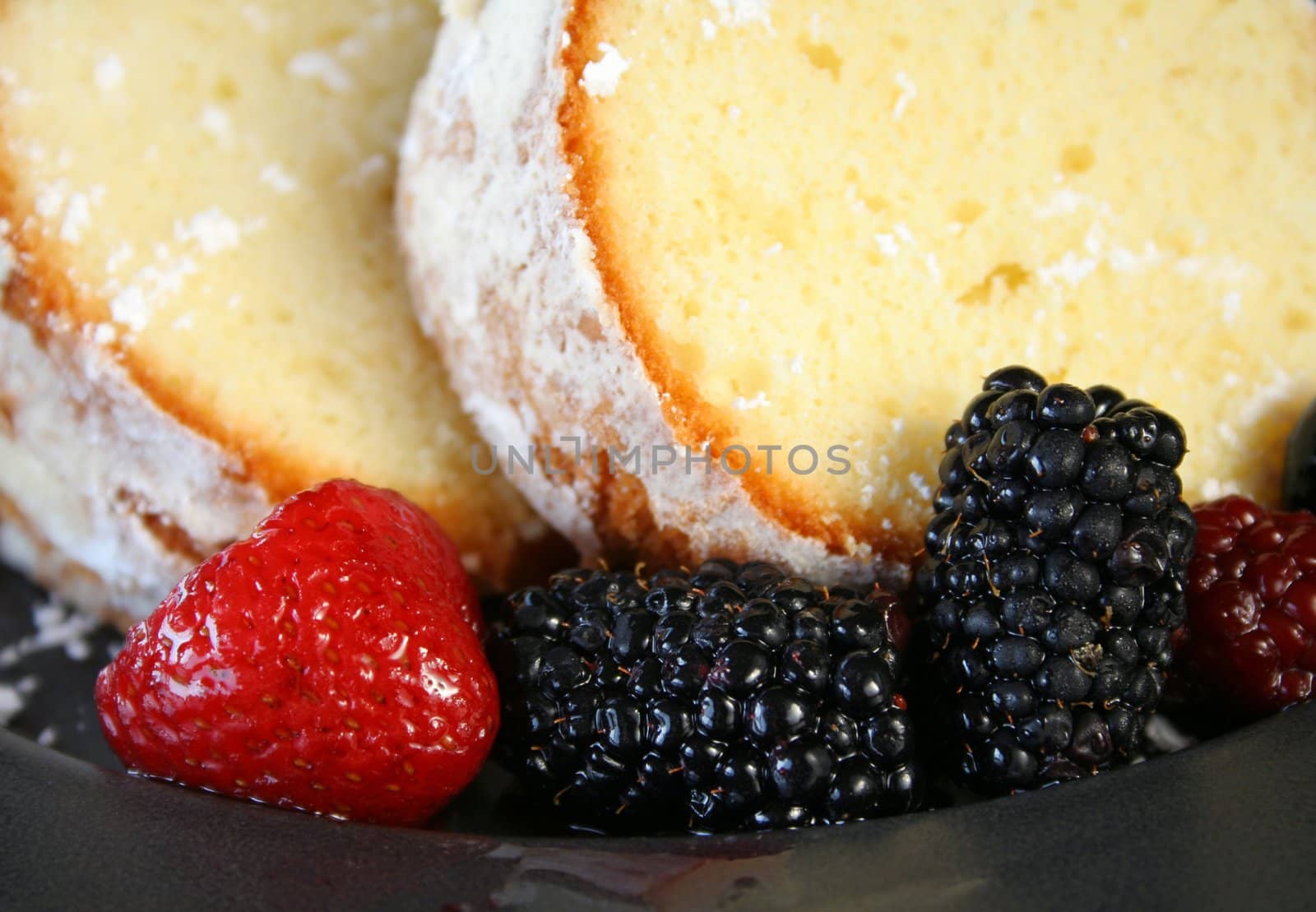 close up of mixed berries and home made pound cake.