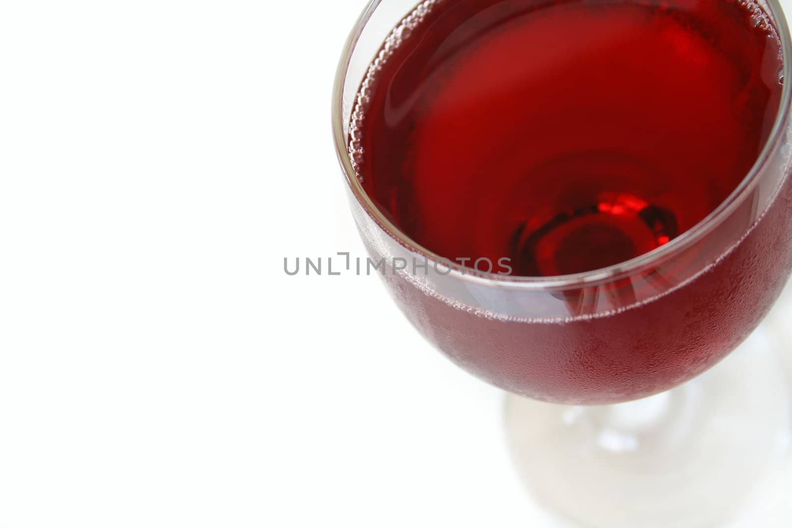 Red wine, macro view with focus on both sides of the lip of glass and very front of glass. Isolated on white with copy space.
