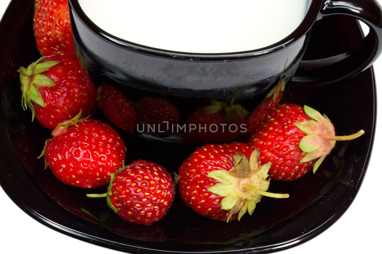 close-up black cup of milk and strawberries, isolated on white