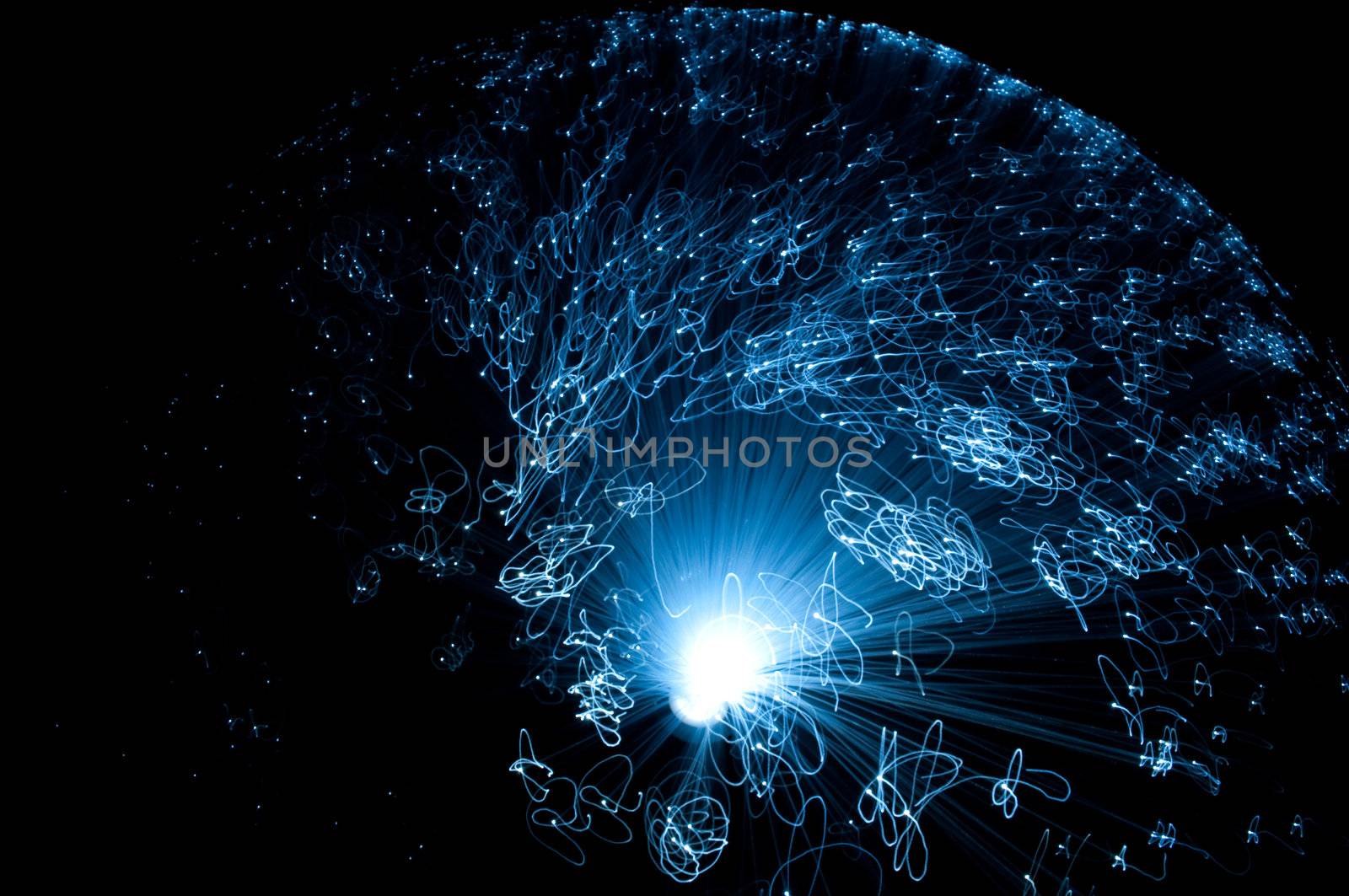 Close up and aerial capturing the motion of an illuminated fibre optic lamp against black background.