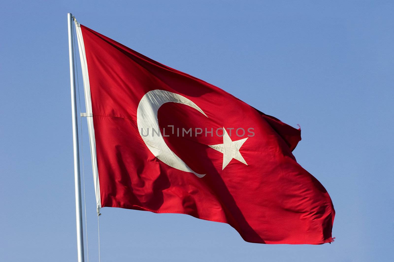 National flag of Republic of Turkey waving against blue sky. Clipping Path included to easy replace background.