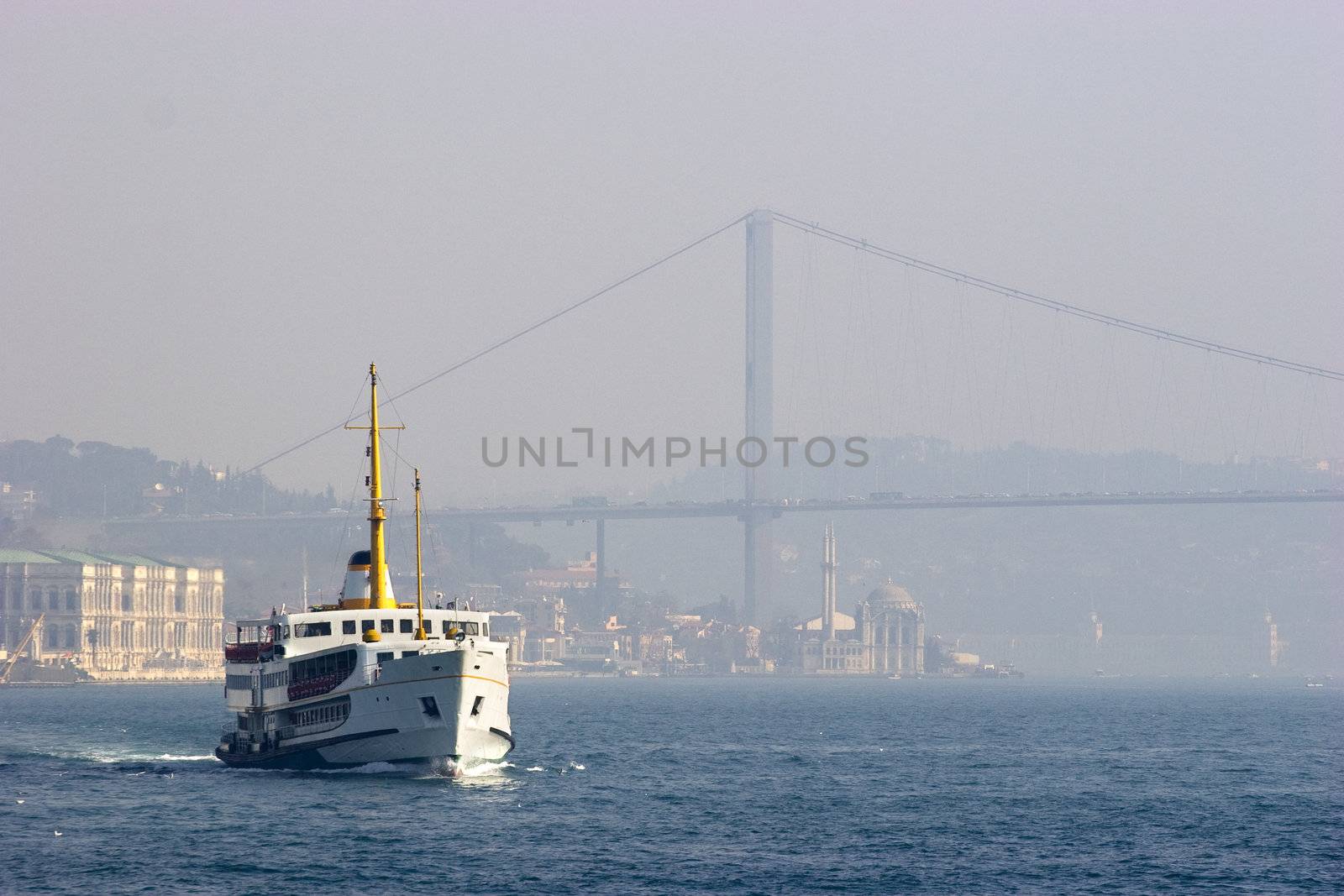 Passenger ferry sails between two continents, Europe and Asia in Bosporus Strait, Istanbul, Turkey. Foggy day