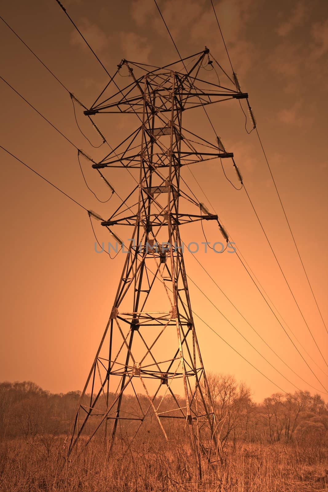 Power transmission pole against sunset skies