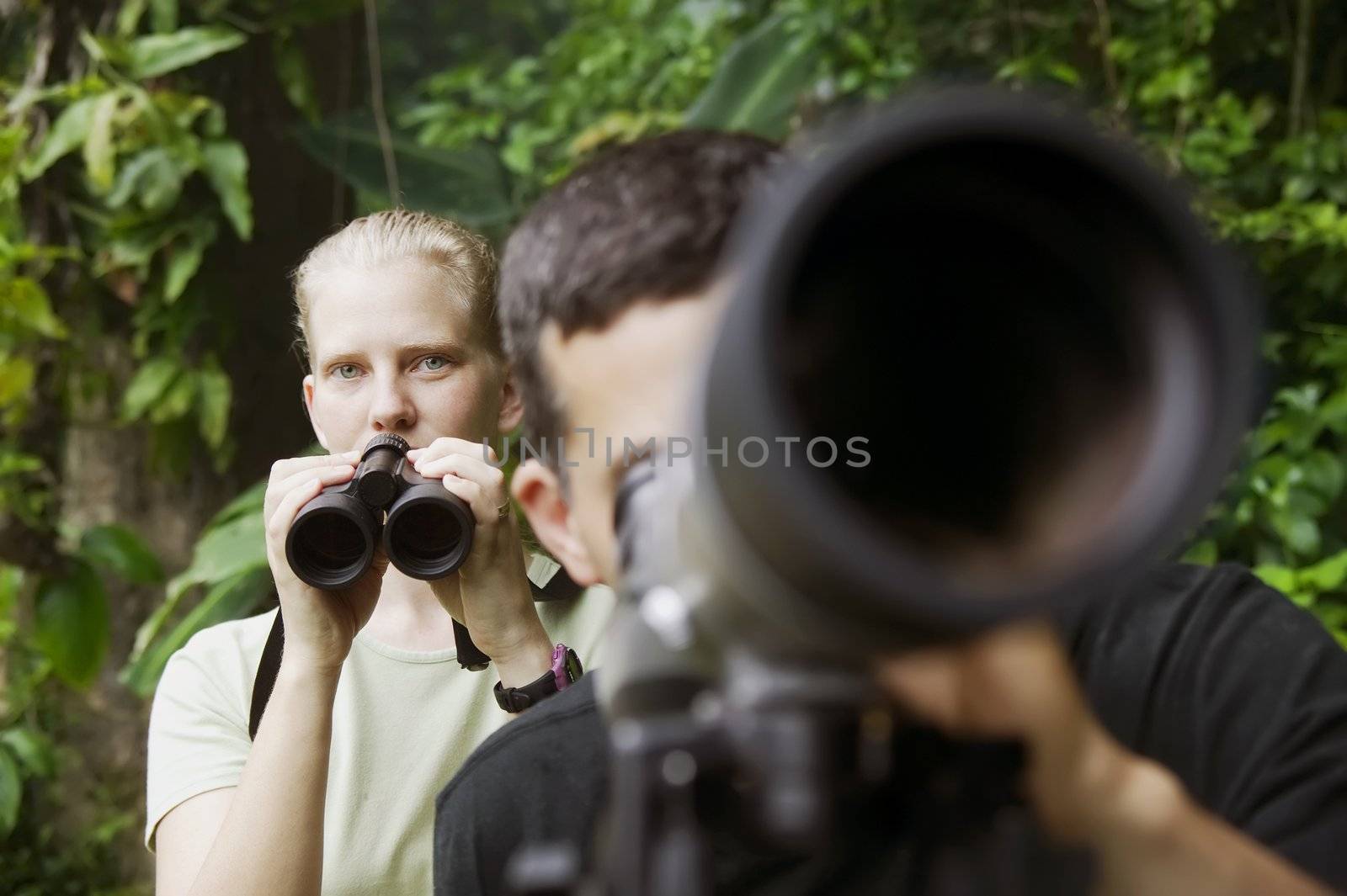 Pretty Woman with Binoculars and Man with Telescope in Jungle by Creatista