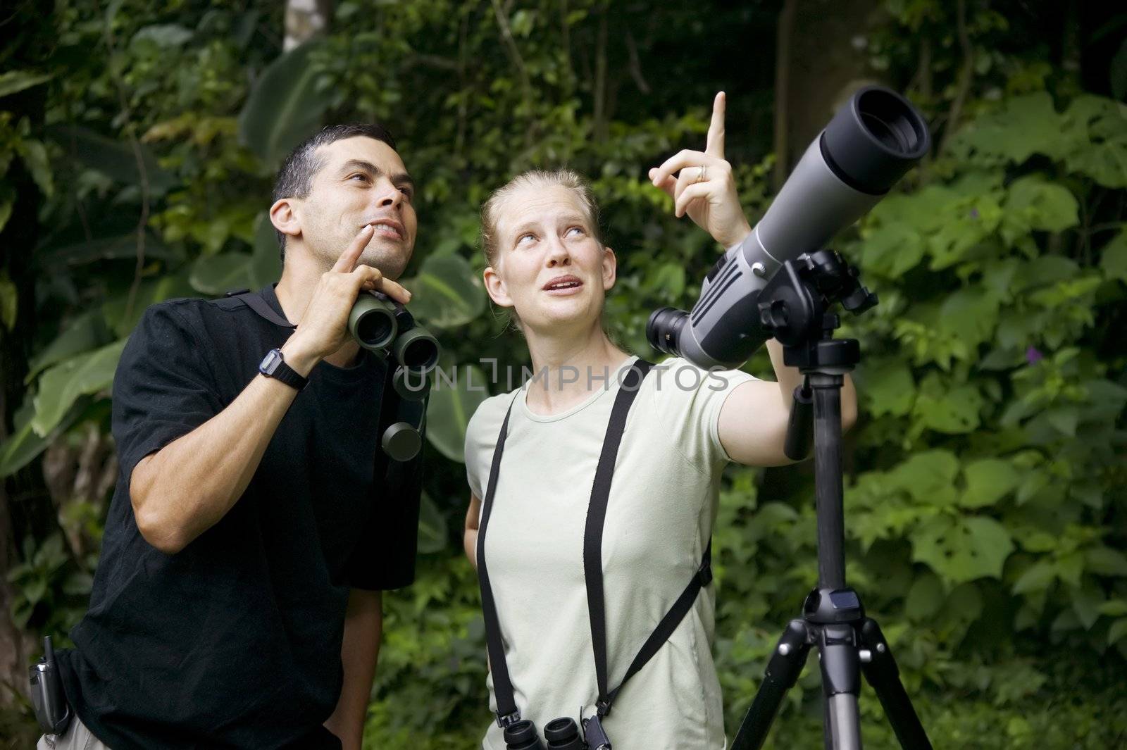 Pretty Woman with Binoculars and Man with Telescope in Rain Forest Jungle