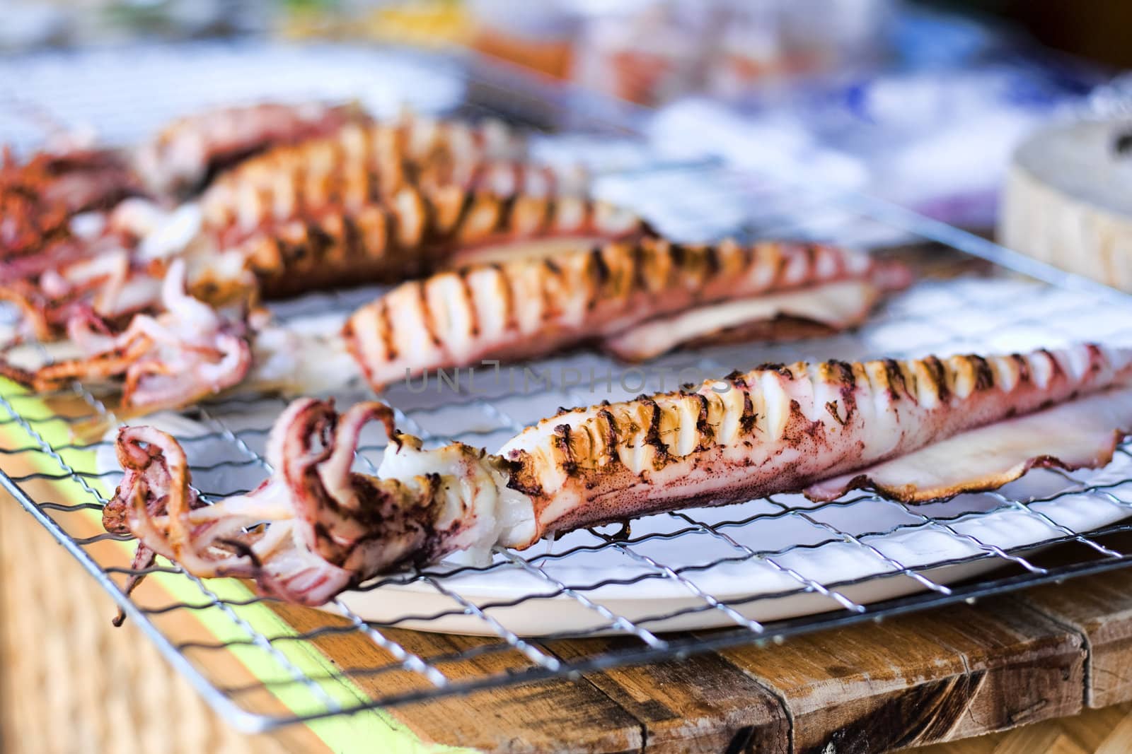 Freshly grilled squid cooling on racks in Thai market