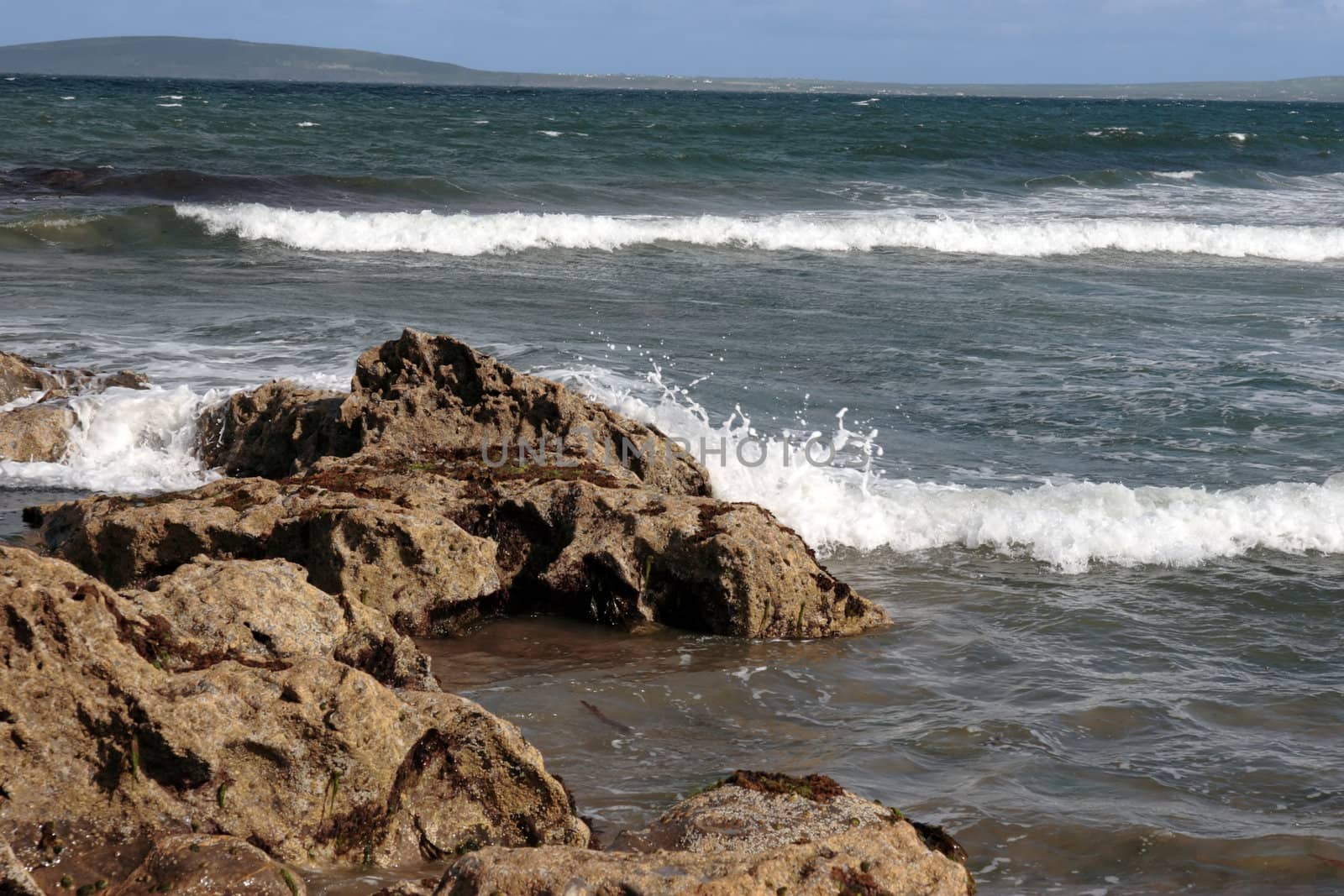 a rocky beach on a warm day with a calm sea an ideal place to have a walk in ireland